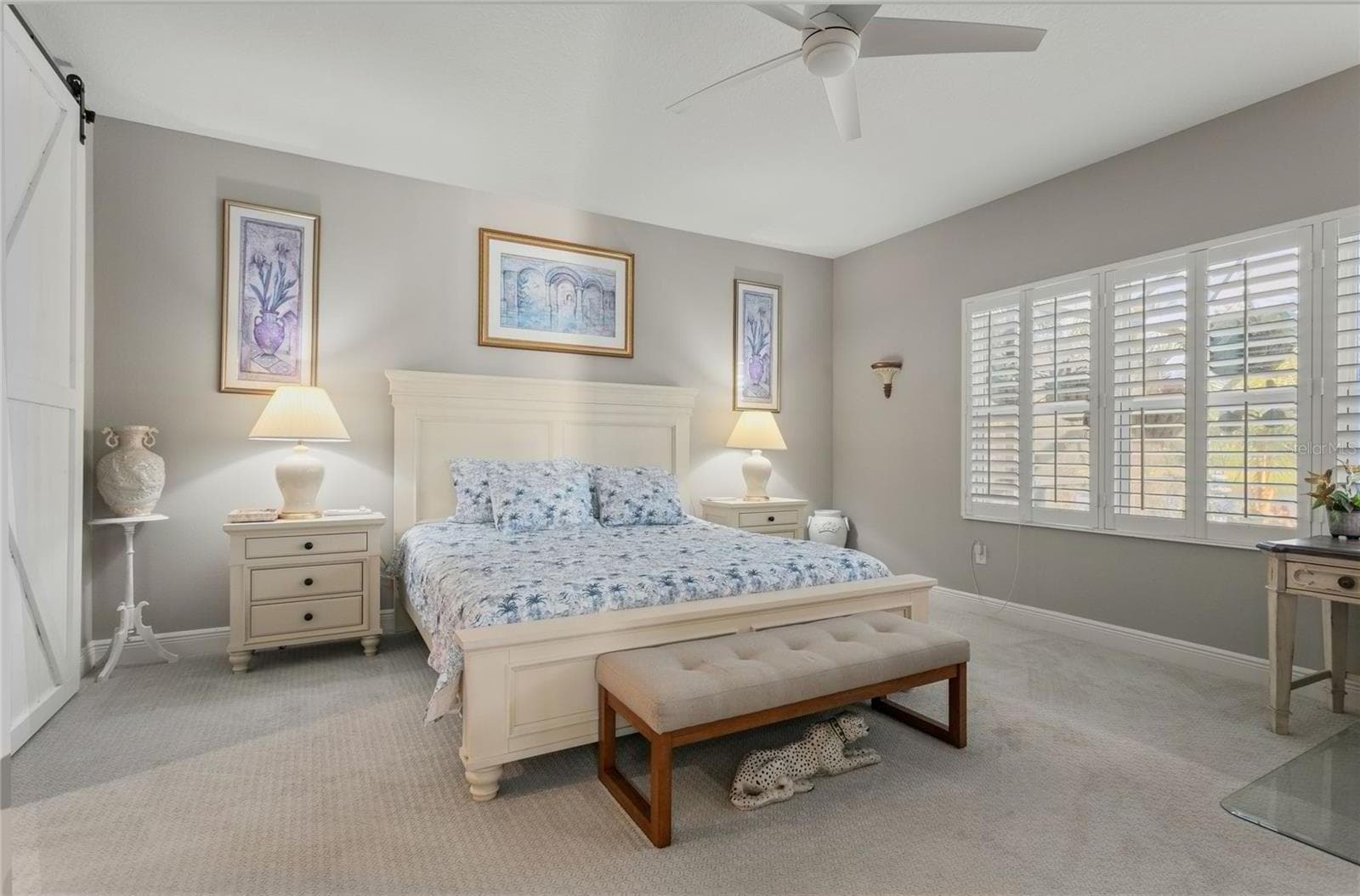Spacious primary bedroom with abundant natural light, plantation shutters, soft neutral walls, and a serene, well-appointed layout designed for comfort and relaxation - 10625 FALLING LEAF CT, PARRISH