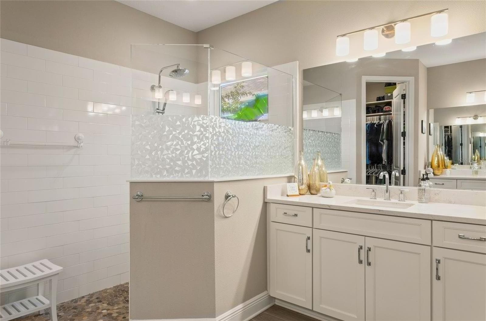The second individual sink vanity mirrors the home’s modern design, offering its own dedicated cabinetry and a clear view of the spacious walk-in shower, all thoughtfully arranged to complement the primary suite’s custom-designed walk-in closet - 10625 FALLING LEAF CT, PARRISH