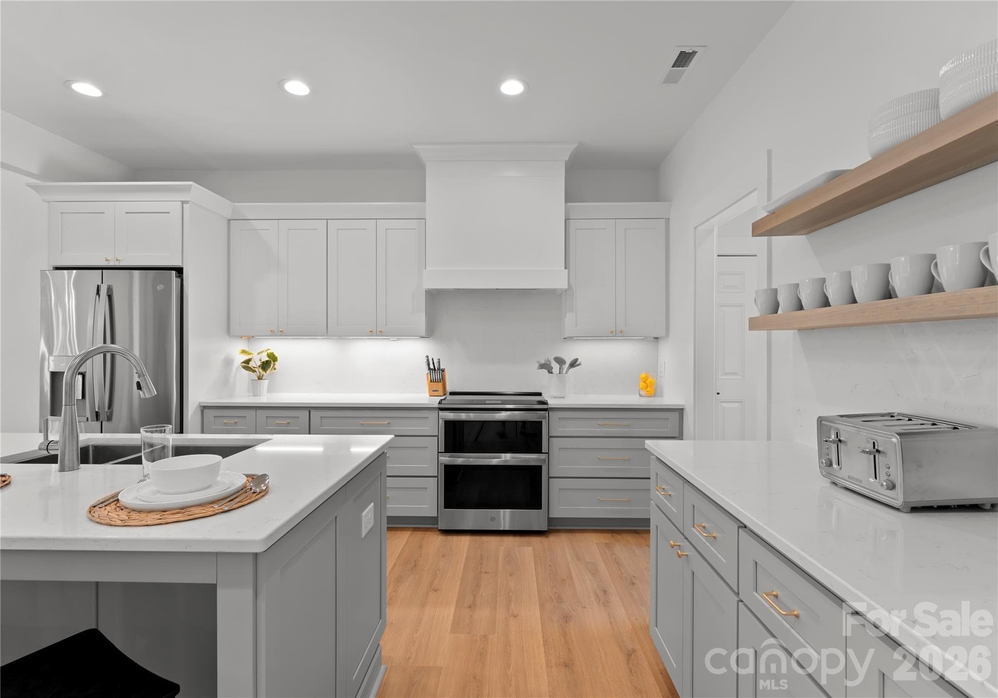 The fully equipped kitchen is equally suited for intimate meals or larger gatherings, with open shelving and sleek countertops creating a polished, professional look. - 143 Hideaway Lane, Mooresville