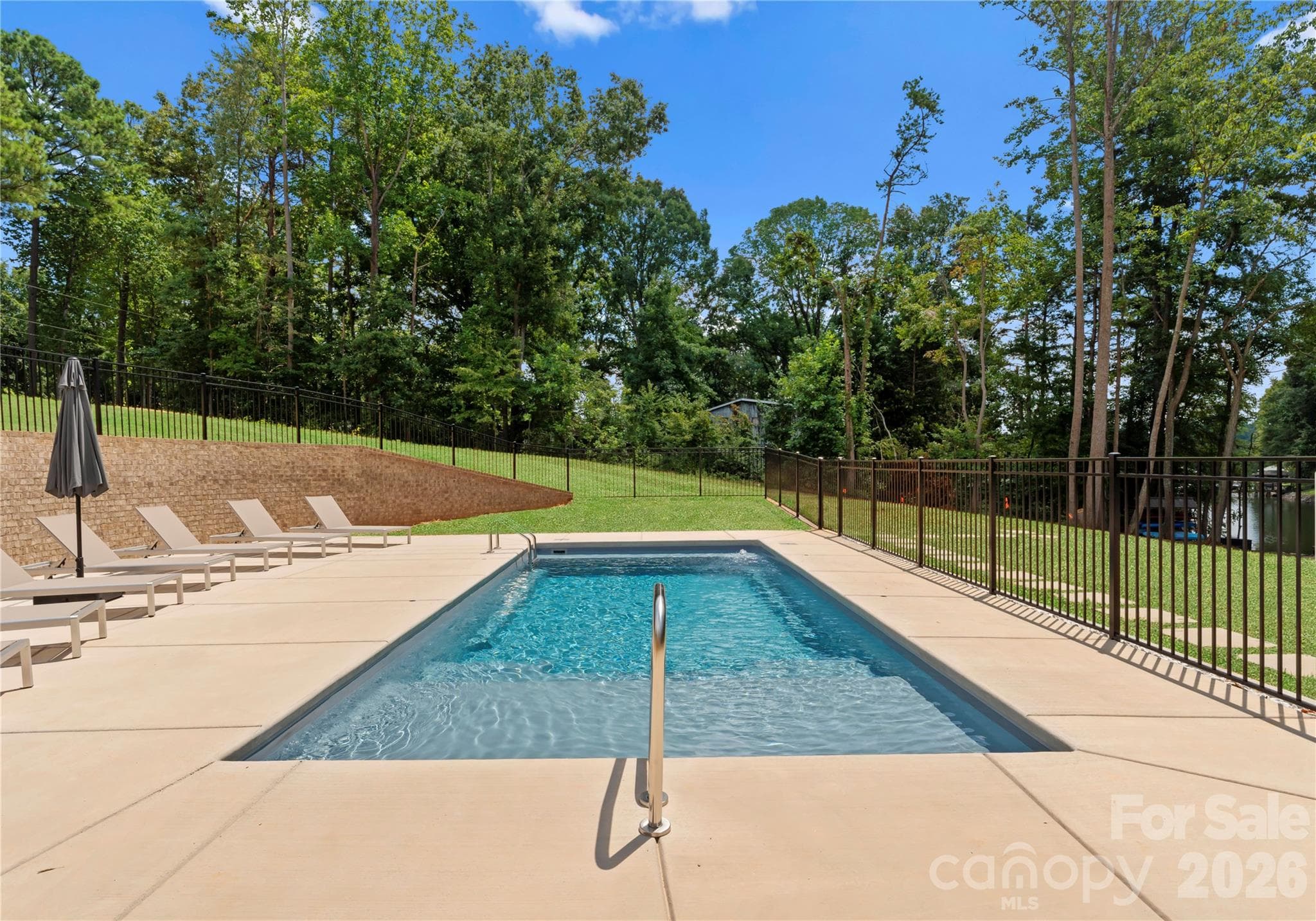 The magnificent heated pool and broad pool deck provides ample room for multiple loungers and broad views across the property to the dock and lake beyond. - 143 Hideaway Lane, Mooresville