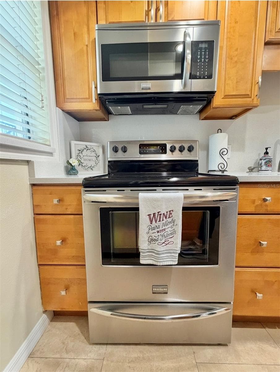 Stainless appliances and a view out the window to the front porch. - 3815 N OAK DR #G71, TAMPA
