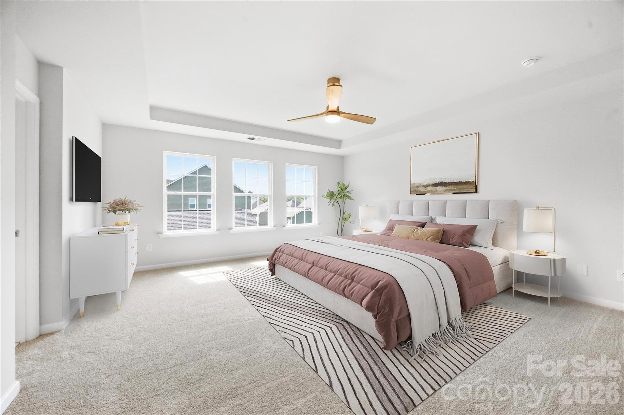 Spacious primary suite features a tray ceiling, abundant natural light, and plenty of room for a king-size bed and additional furnishings - 2015 Kensley Drive, Waxhaw