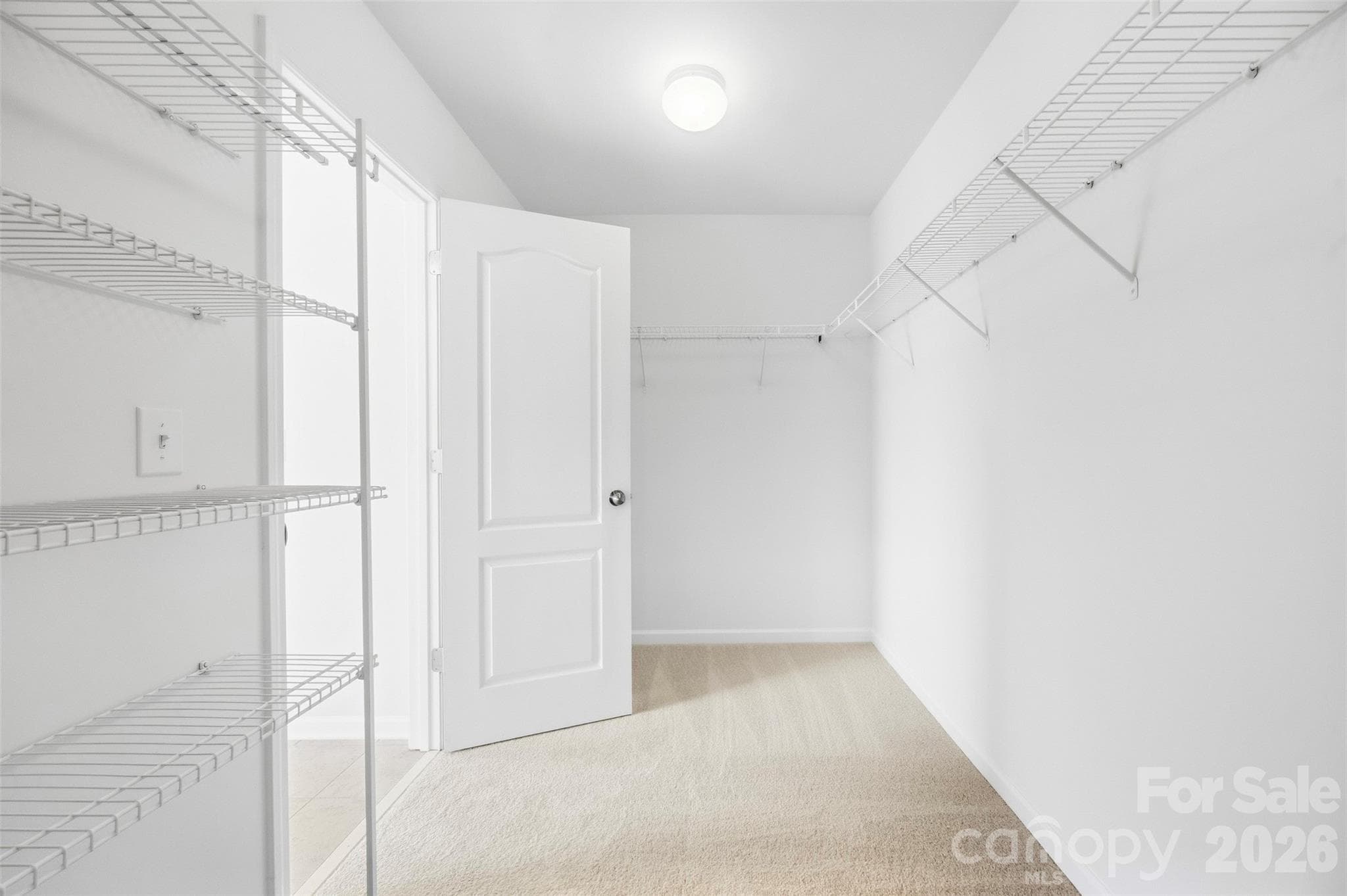 Oversized primary walk-in closet offers extensive shelving and abundant storage space - 2015 Kensley Drive, Waxhaw