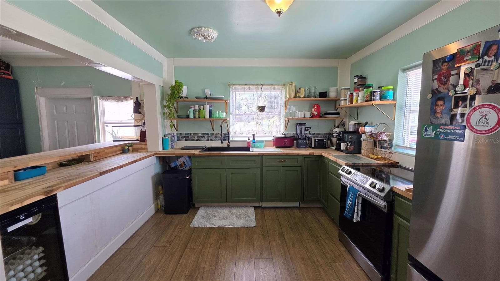 Kitchen with Butcher Block Countertops, Stainless appliances, Decorative Shelving, 2 Windows, and Laminate Flooring - 1702 26TH ST W, BRADENTON