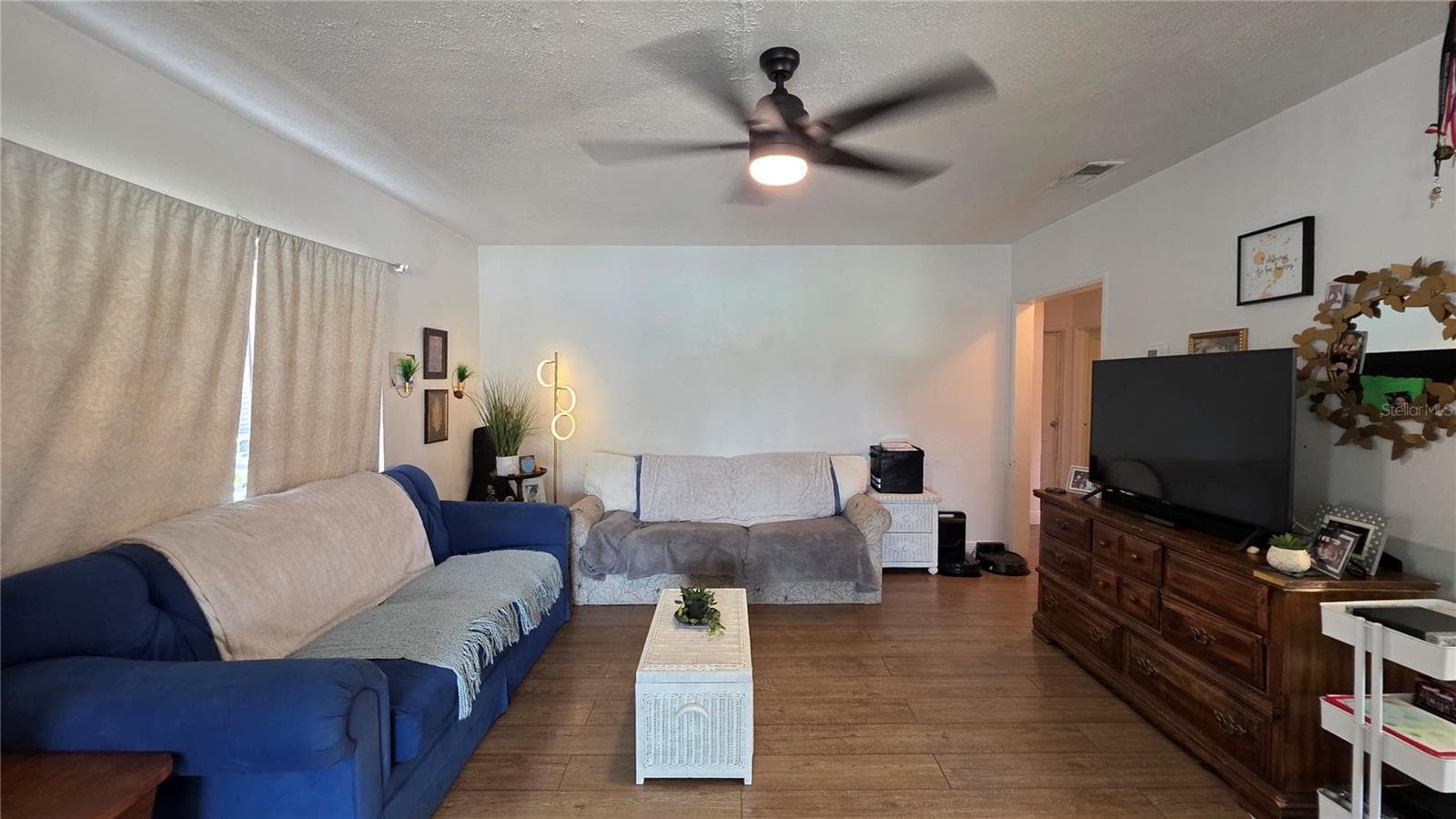 Living Room with Ceiling Fan, Laminate Flooring, and Window overlooking Front Yard - 1702 26TH ST W, BRADENTON