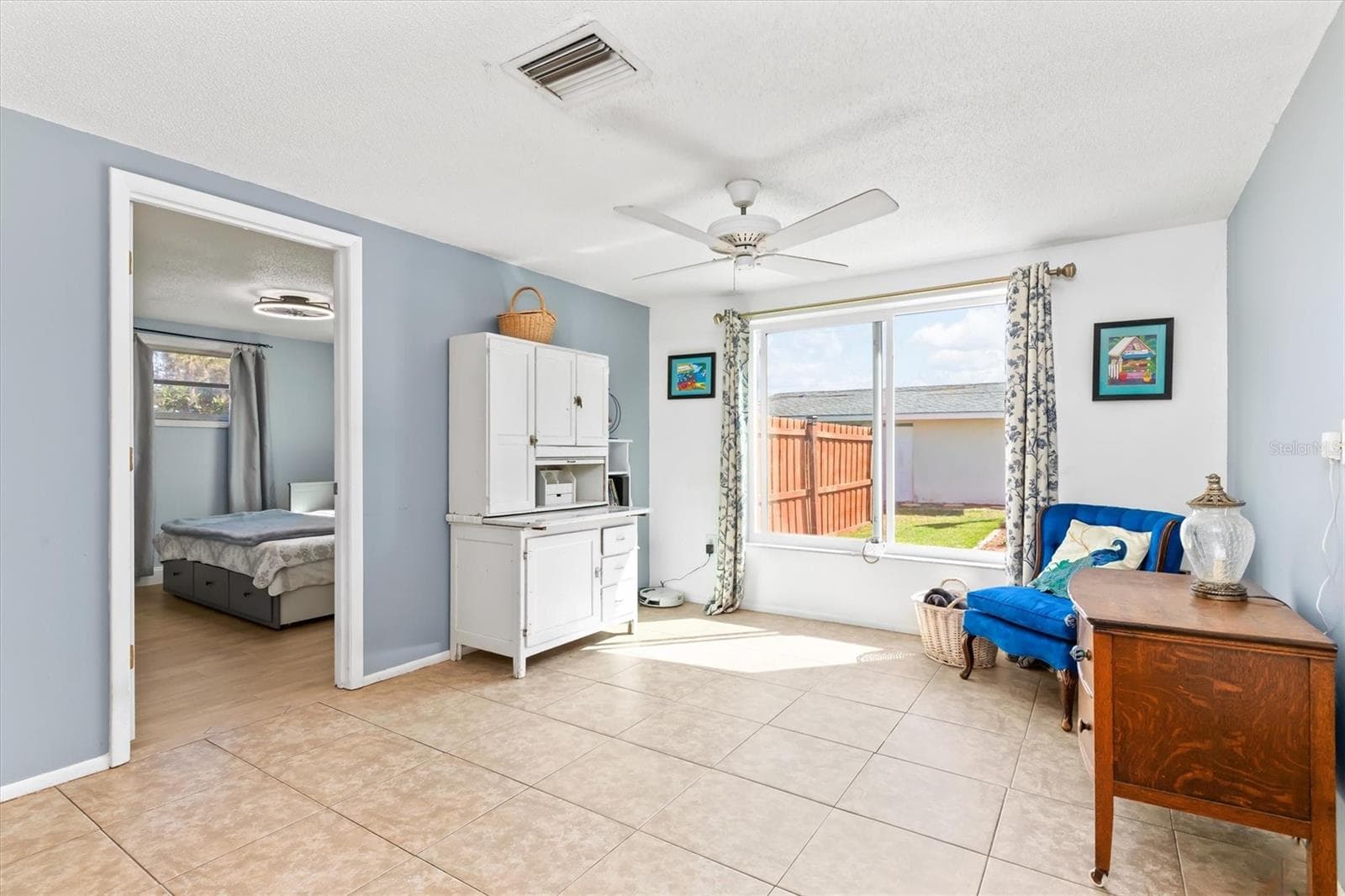 Imagine relaxing here with the pool just beyond the large picture window. This family room adds another inviting place to gather or unwind. Photo taken during prior occupancy. - 142 2ND AVE, NOKOMIS