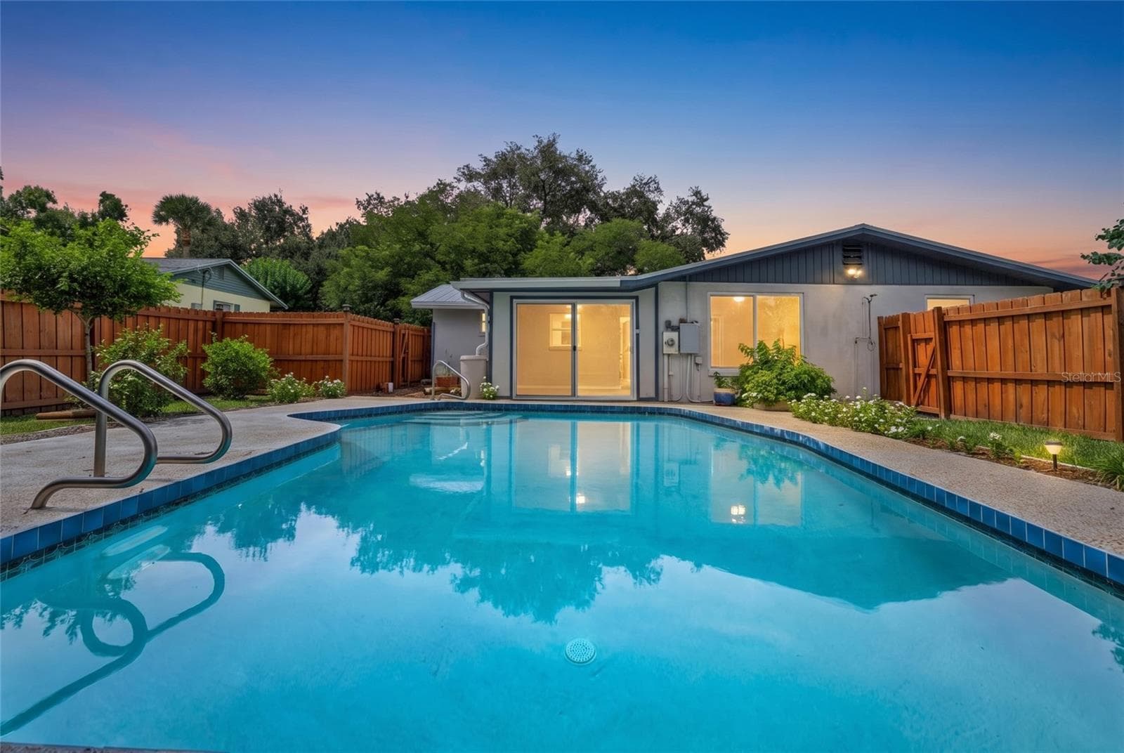 Private backyard pool surrounded by tropical landscaping, creating a peaceful Florida retreat just minutes from Gulf beaches. - 142 2ND AVE, NOKOMIS