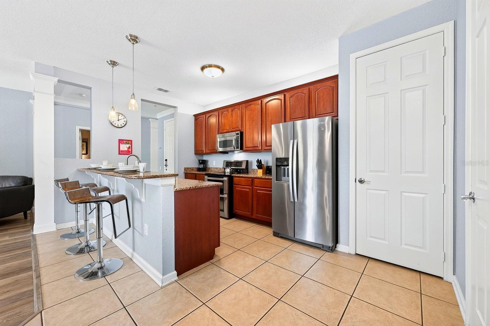 The well-appointed kitchen offers STAINLESS STEEL APPLIANCES, generous cabinet and counter space, a pantry and BREAKFAST BAR for casual dining. - 5049 SHOREWAY LOOP #1-201, ORLANDO