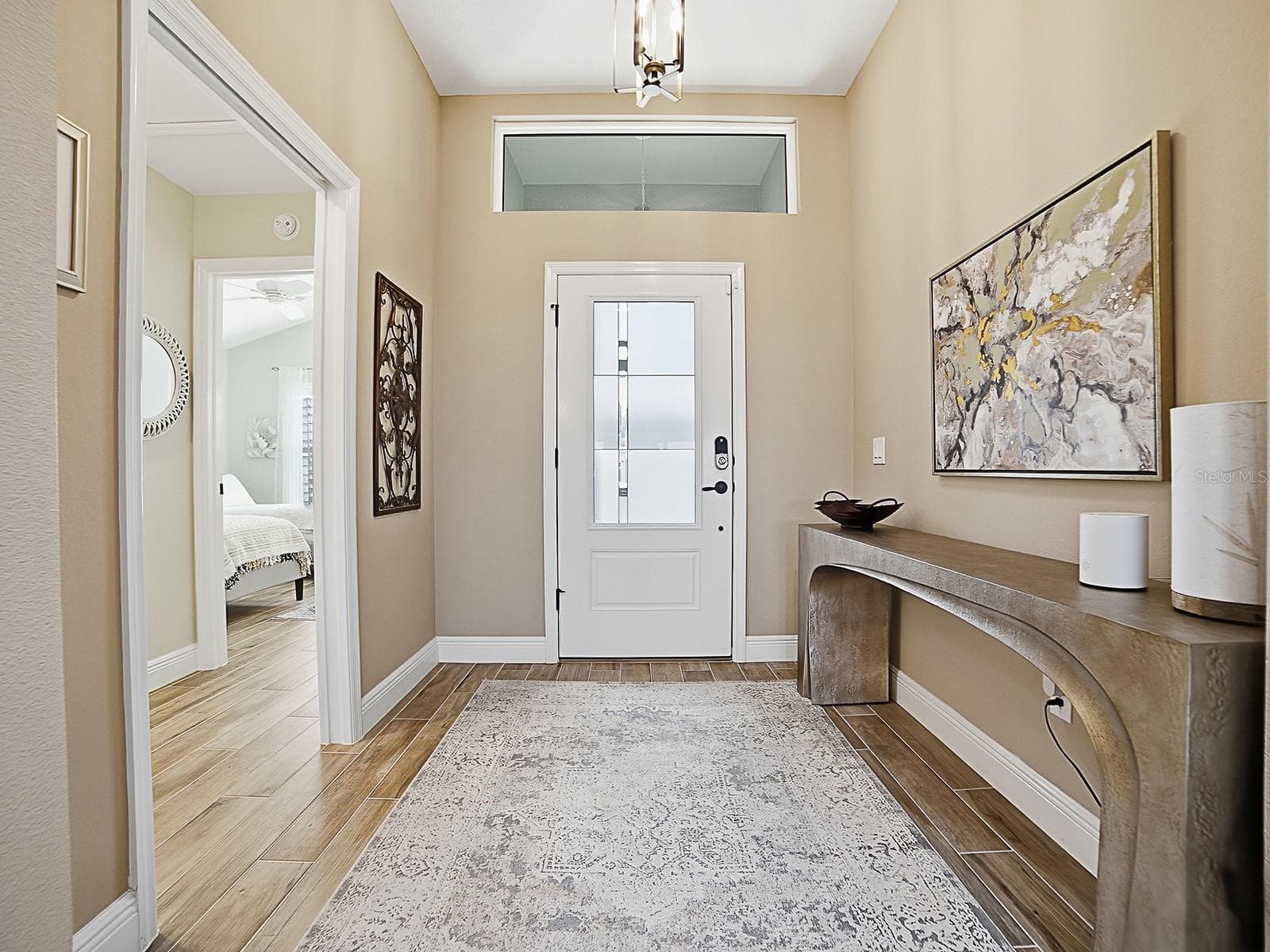 WOOD-LOOK PORCELAIN TILE FLOWS THROUGHOUT THE HOME! NICE LARGE FOYER WITH A POCKET DOOR THAT LEADS TO ONE OF THE GUEST SUITES. - 3075 LICCIARDELLO PATH, THE VILLAGES
