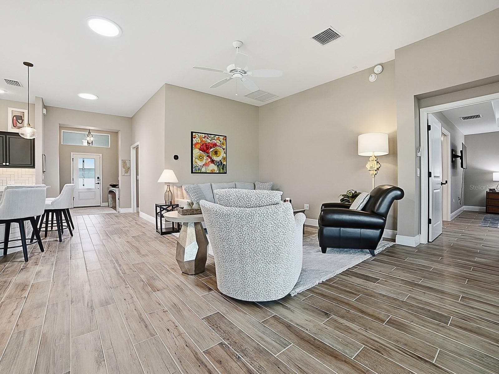 OPEN FLOOR PLAN WITH SOLAR TUBES THROUGHOUT THE HOME FOR NATURAL LIGHTING. THE POCKET DOOR TO THE RIGHT LEADS TO ANOTHER GUEST SUITE AND LAUNDRY. THE KITCHEN IS TO THE LEFT. - 3075 LICCIARDELLO PATH, THE VILLAGES