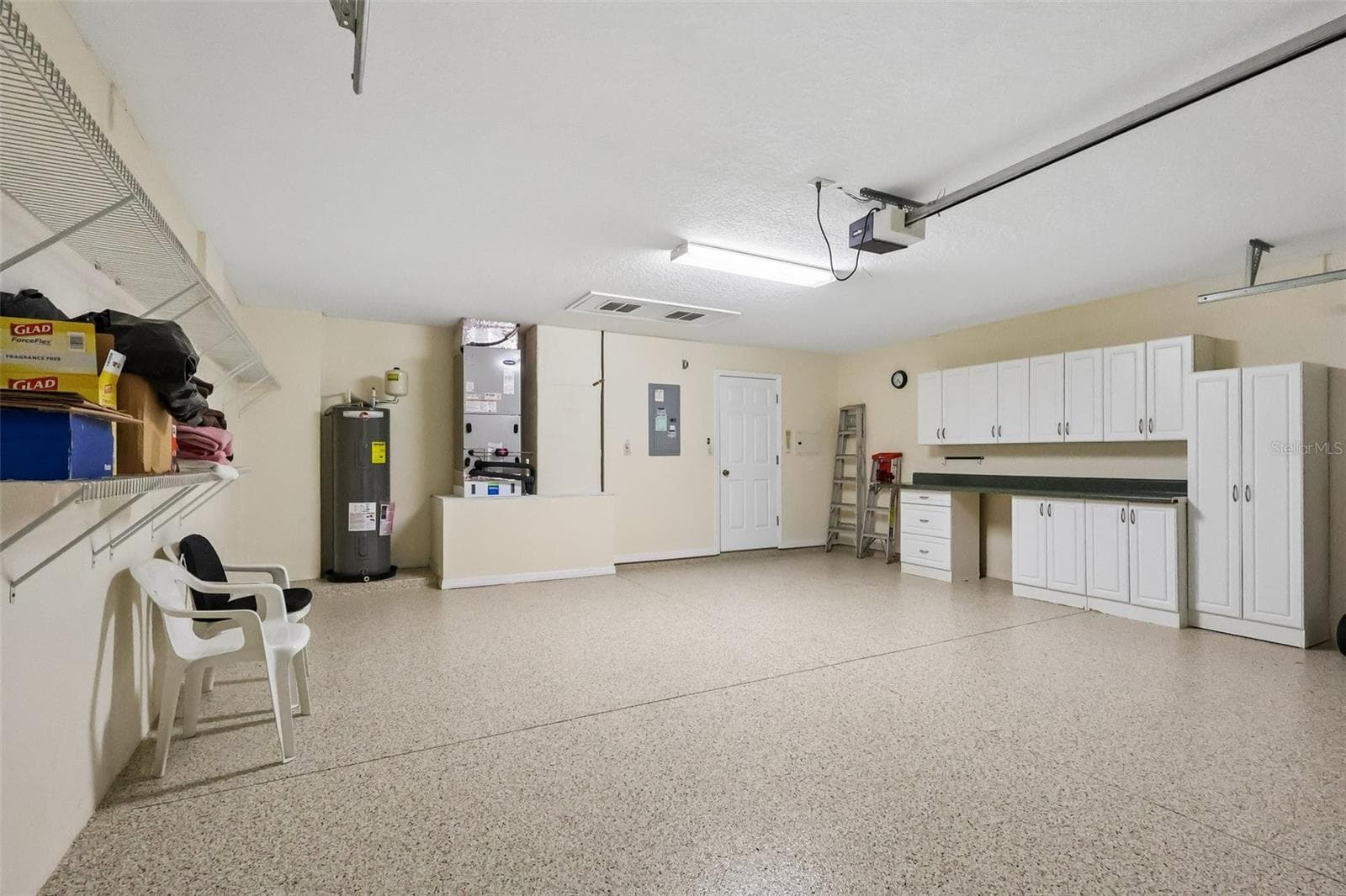 Freshly Painted Epoxy Garage Floor with Storage Cabinets and Workbench - 24445 MADEWOOD AVE, LEESBURG