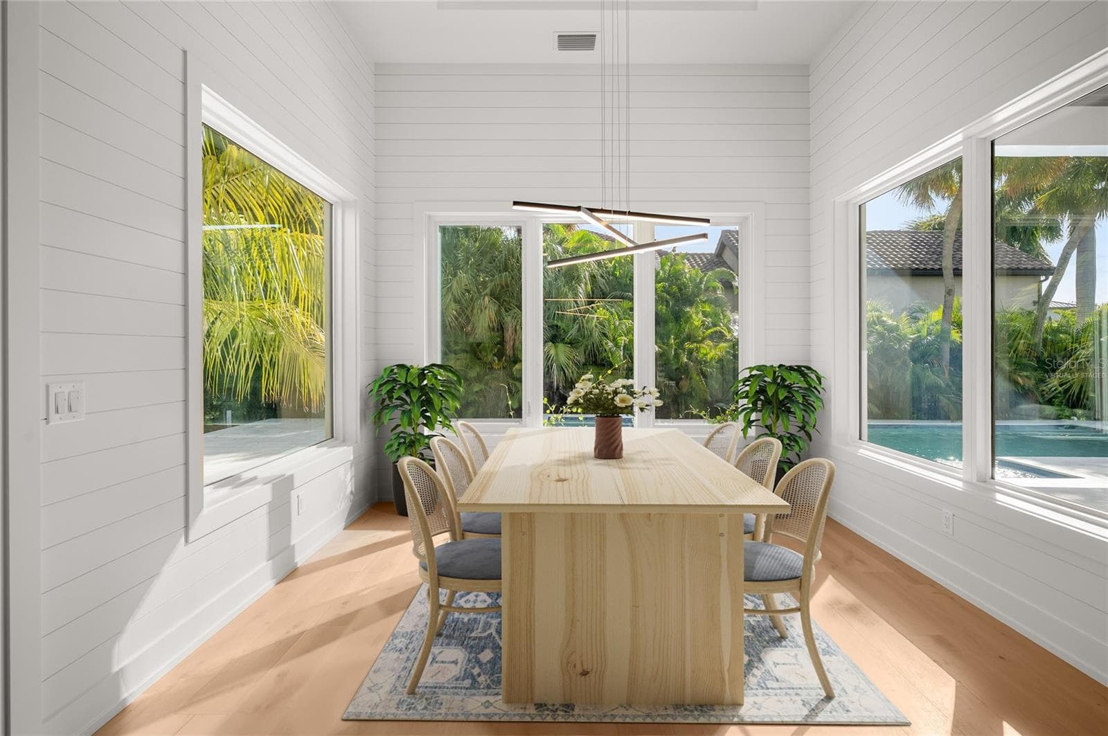 Virtually staged dining nook with elegant shiplap detailing, overlooking the private, beautifully landscaped backyard and pool. - 3360 BAYOU SOUND, LONGBOAT KEY