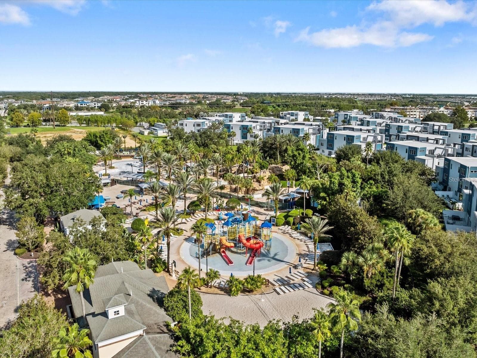Resort Water Park & Community View: Broad aerial view highlighting the water park amenities, clubhouse grounds, and surrounding residential developments. - 7656 WHISPER WAY #102, REUNION