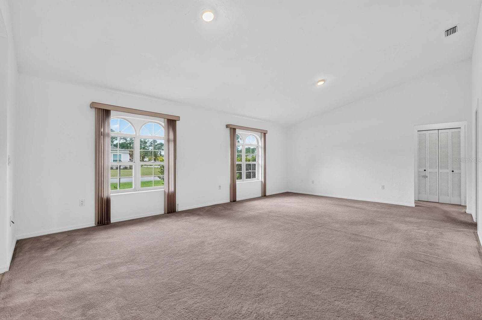 large living room with arched windows - 156 BRESSLER LN, PALM COAST