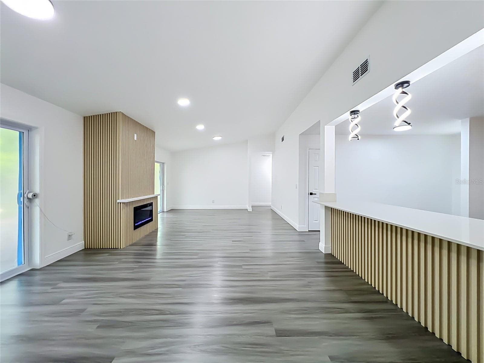 Bright, open living area with modern flooring and recessed lighting. - 5610 SHASTA DR, ORLANDO