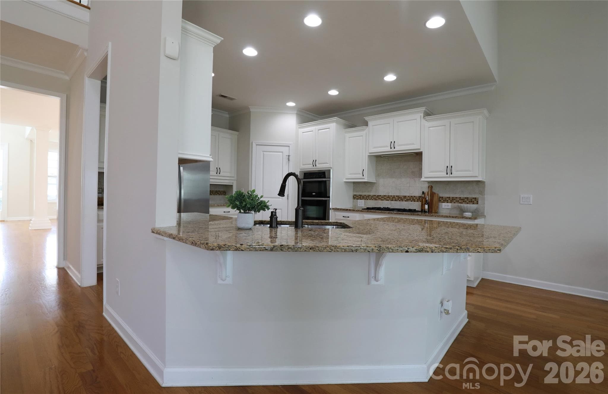 Kitchen peninsula faces views of sunroom and rear yard and is open to great room - 18465 E Marbella Lane, Fort Mill