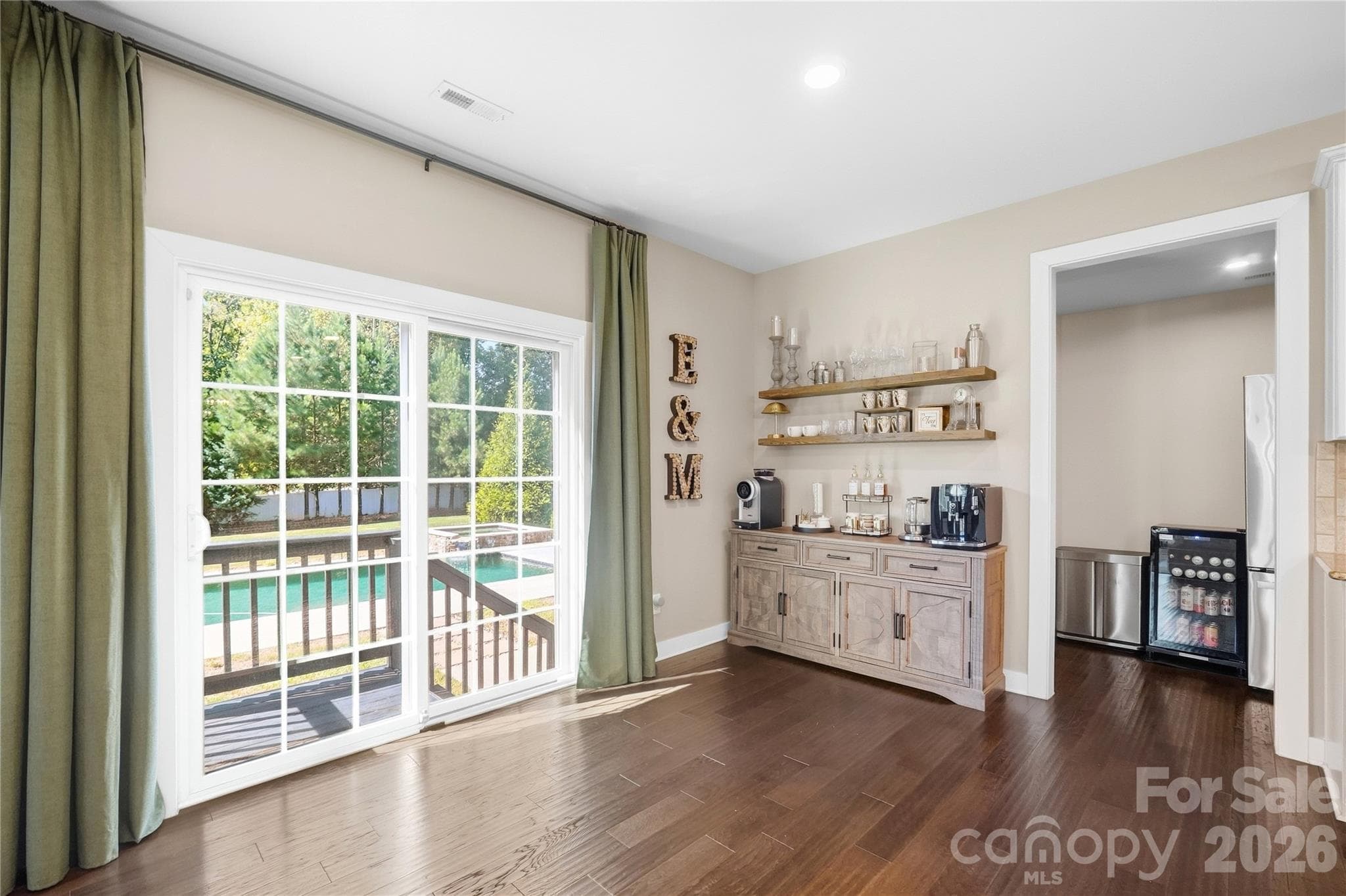 Breakfast area with a sliding glass door to the deck, with views of the heated saltwater pool and spa. - 912 Manorwood Drive, Waxhaw