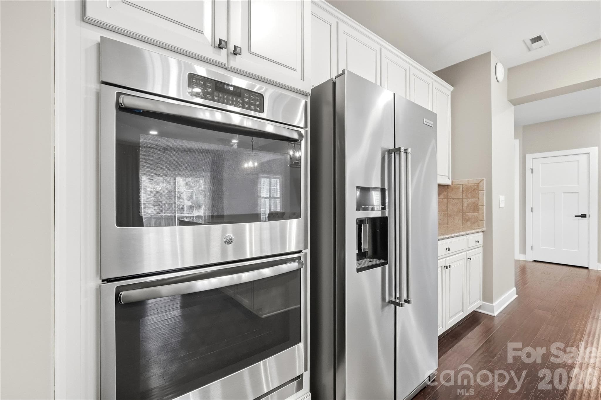 Stainless appliances, including a GE double wall oven and a KitchenAid side-by-side refrigerator (purchased 2024). - 912 Manorwood Drive, Waxhaw