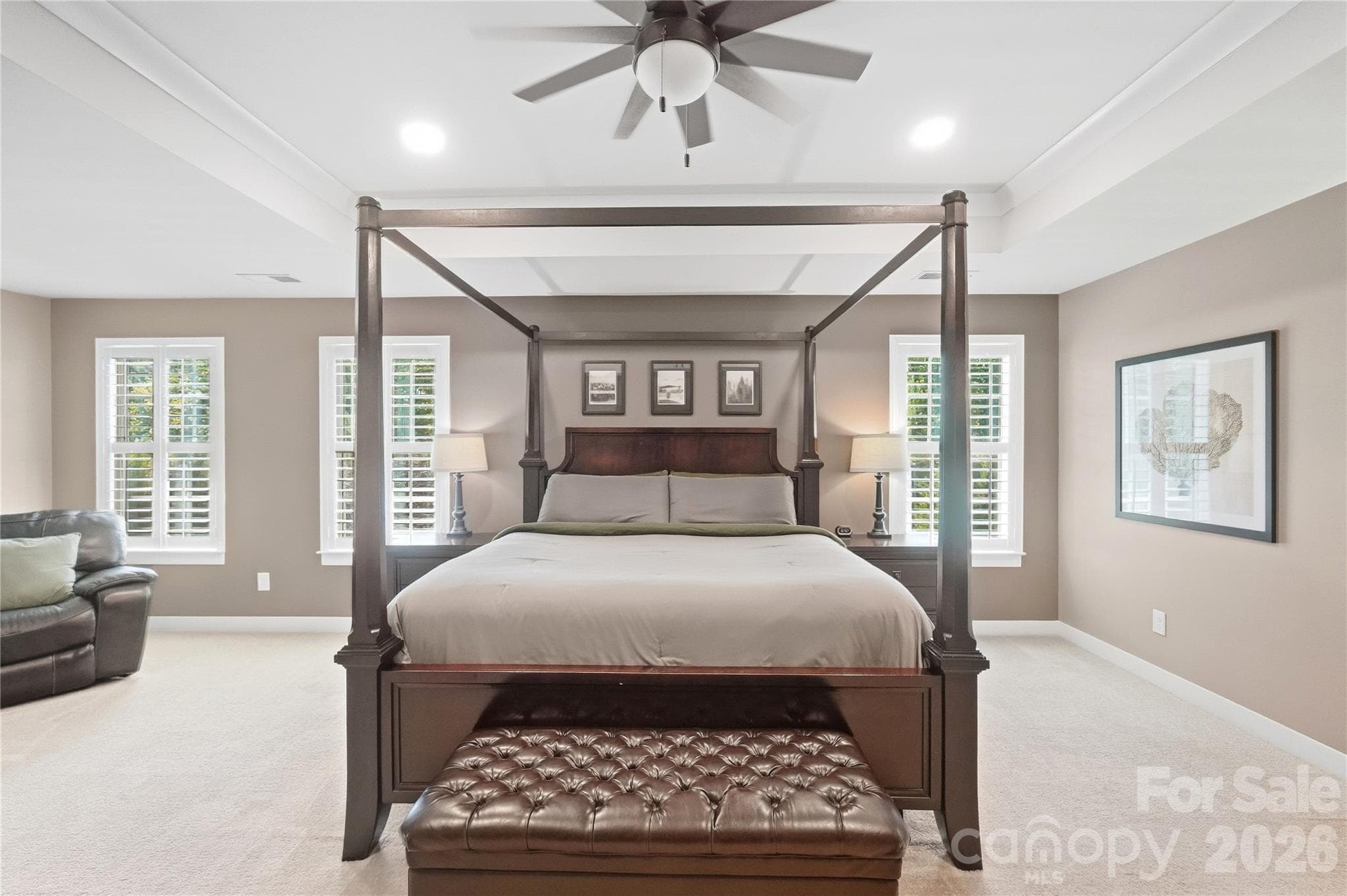 The primary bedroom has room for a king bed and additional seating, with windows on multiple walls for natural light. - 912 Manorwood Drive, Waxhaw