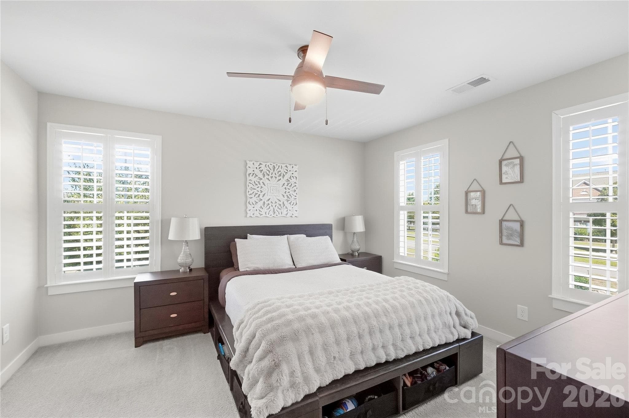 Bedroom 4 with windows on two walls, plantation shutters, and a ceiling fan. - 912 Manorwood Drive, Waxhaw