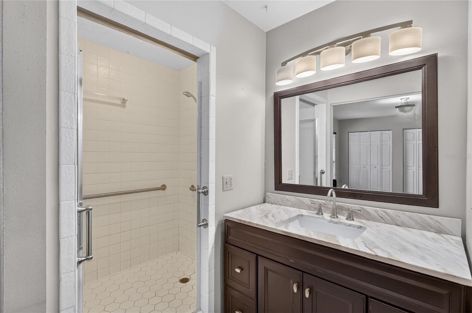 Primary Bedroom features an en suite bathroom, with vanity, separate toilet area, and glass-enclosed shower. - 3011 LAKE ELLEN DR, TAMPA