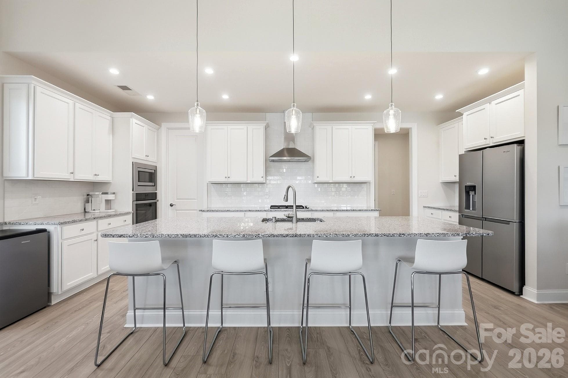 The well-appointed kitchen features ss appliances, gas cooktop, wall oven, a large center island with abundant seating, and a spacious walk-in pantry, all opening to the dining area and great room - 8032 Longwaters Court, York