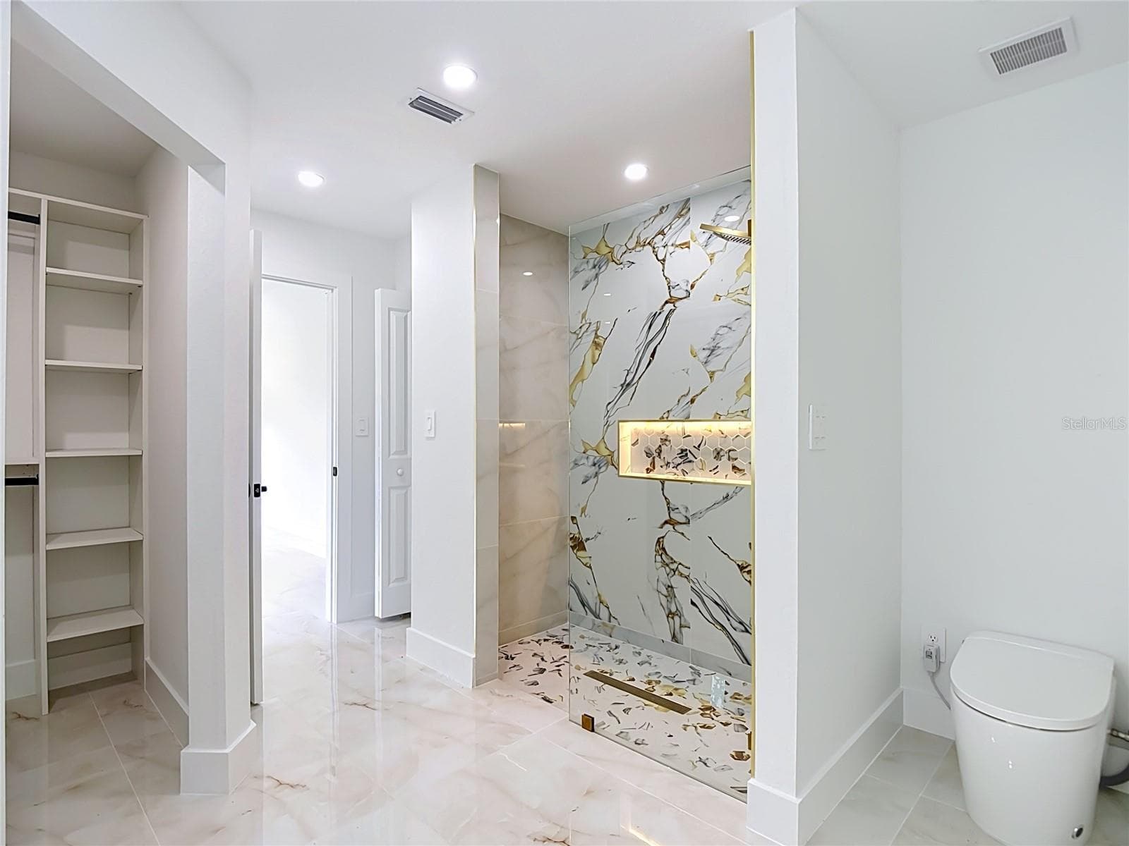 Primary bathroom with walk in closet, exceptional shower and smart toilet with bidet. - 3613 NW 47TH LN, CAPE CORAL