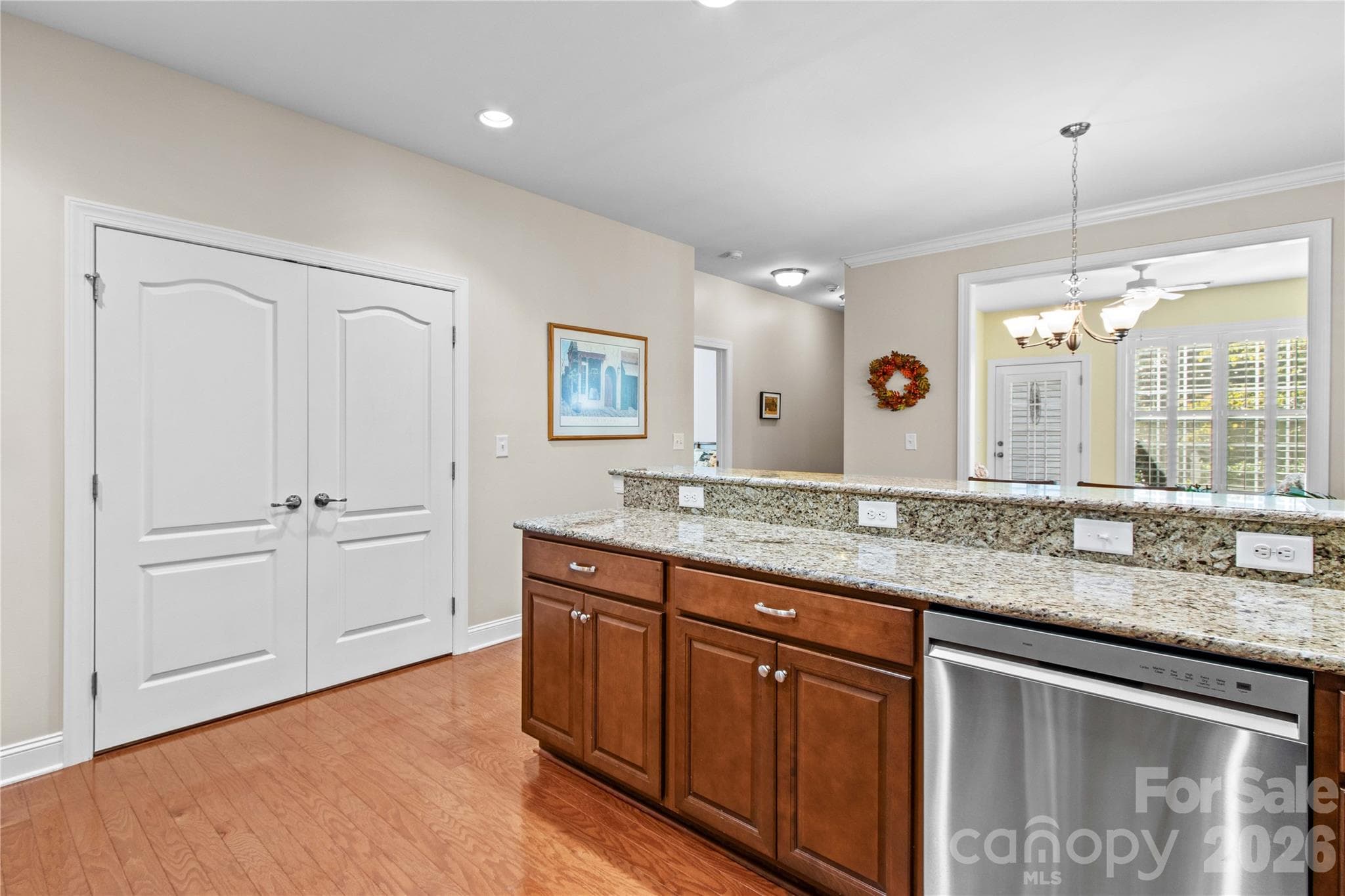 Double doors open to conveniently located laundry with custom wood shelving. - 18114 Ebenezer Drive, Cornelius