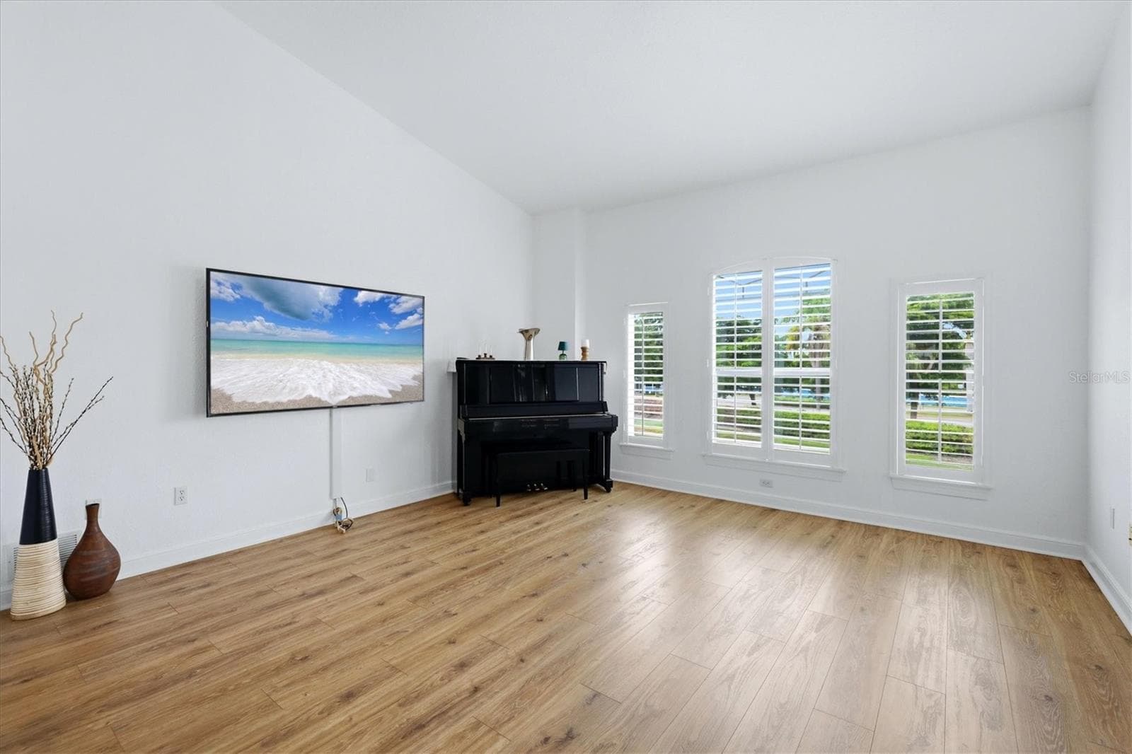spacious family room with plantation shutters, vaulted ceilings, and items that convey - 5458 46TH CT W, BRADENTON