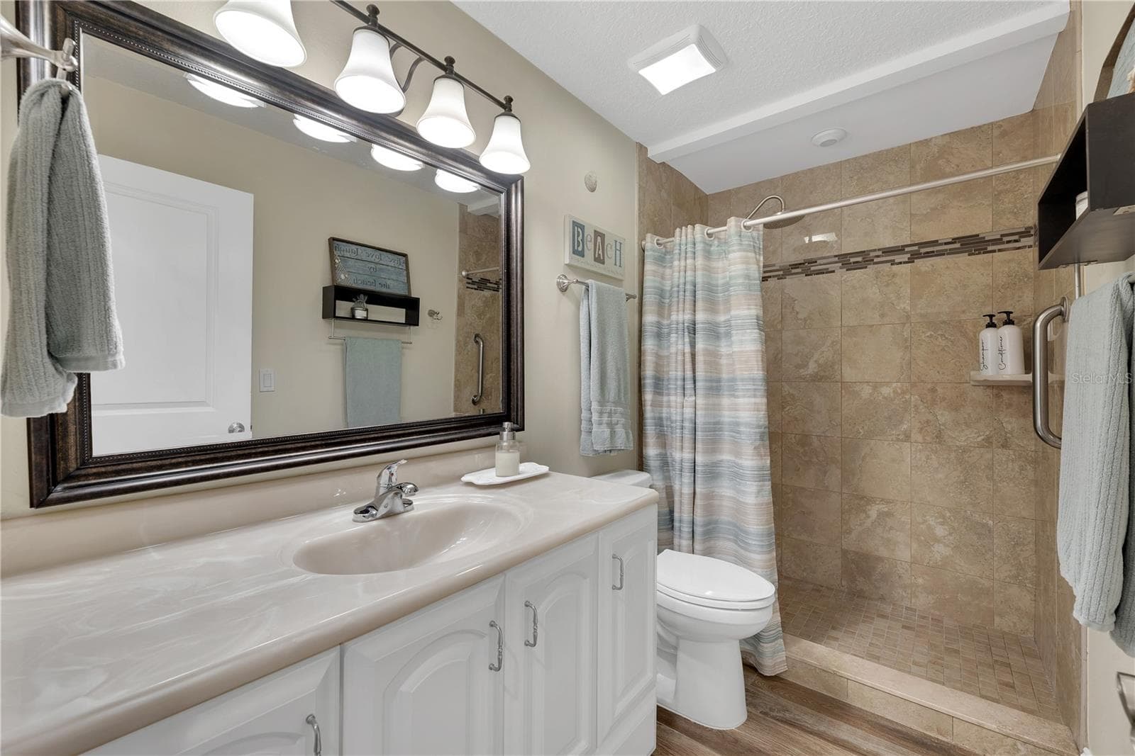 The guest bathroom has been updated with floor to ceiling tile in a spacious walk-in shower. - 743 KINGSTON CT, APOLLO BEACH