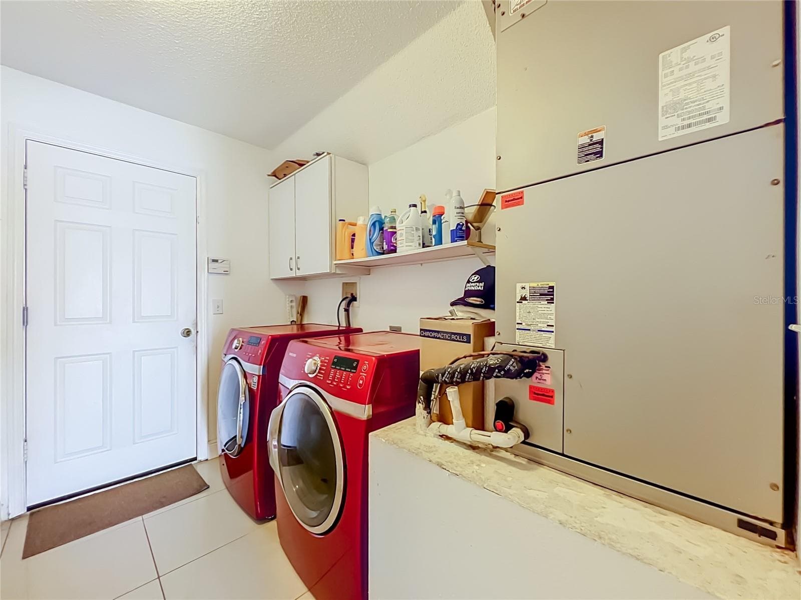 Off the kitchen is the 1st floor inside laundry room with nice Samsung washer and dryer, storage cabinets and storage shelf. Leading to the attached garage. - 12900 LOS ALAMITOS CT, ORLANDO