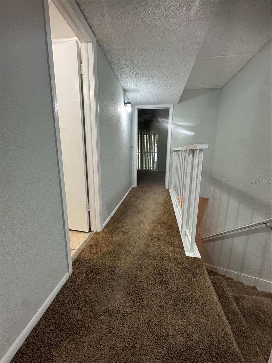 LOOKING FROM TOP OF STAIRS LANDING PAST FULL BATH WITH LINEN CLOSET TO PRIMARY BEDRM - 2884 SOMERSET PARK DR #2907, TAMPA