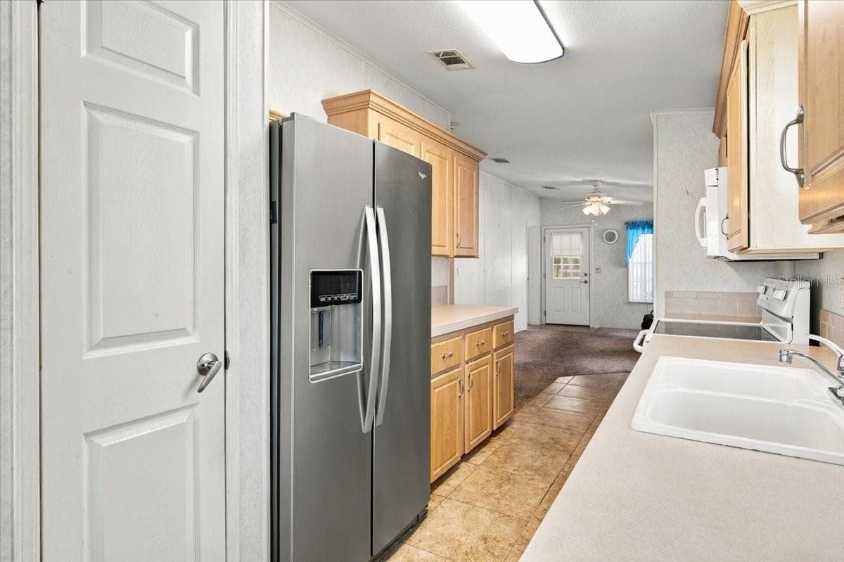 Galley Kitchen with Stainless Fridge - 59 BEAVERKILL DR, LAKE WALES