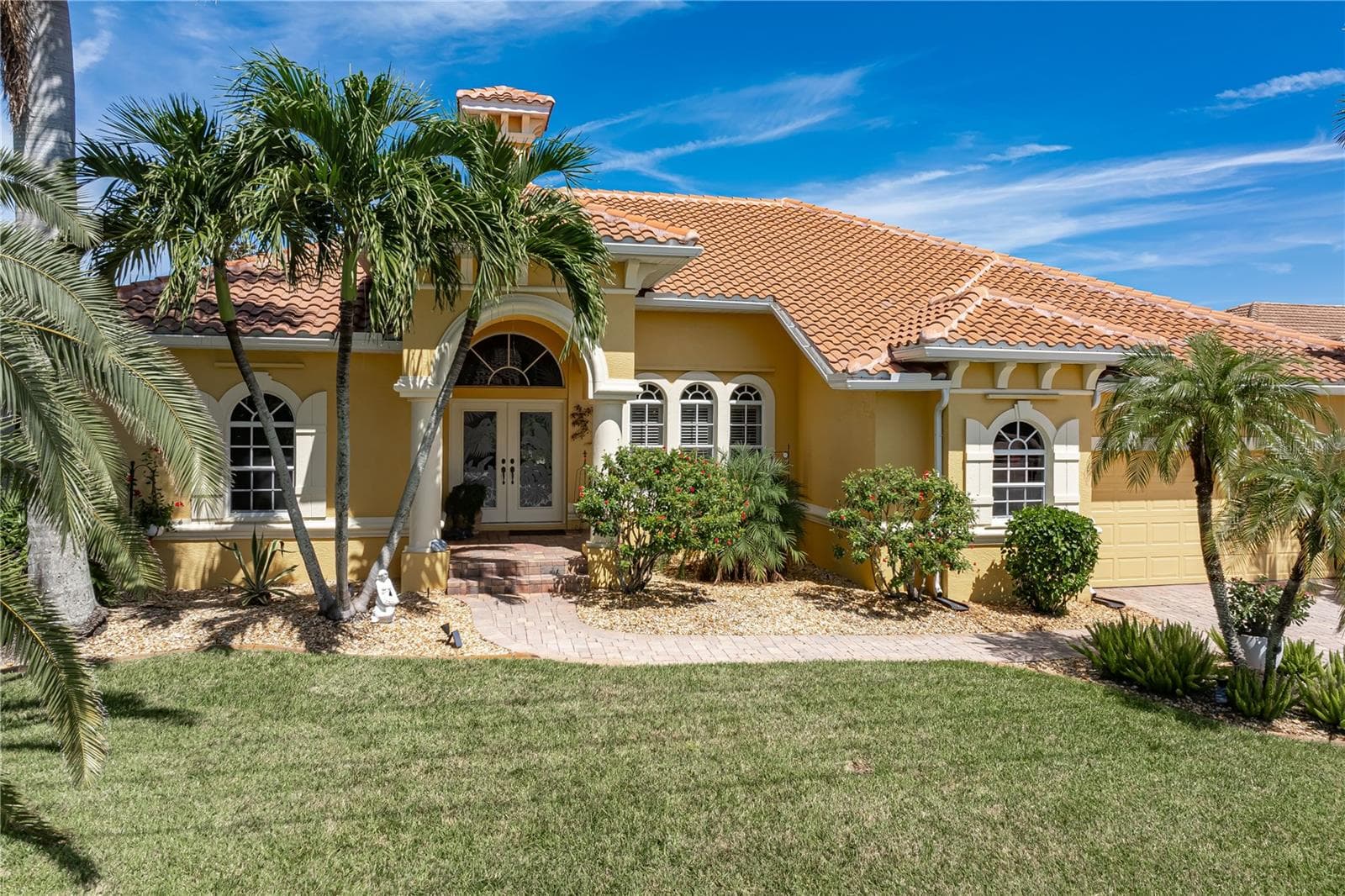Front of home with tropical landscaping and - 1448 KIWI CT, PUNTA GORDA