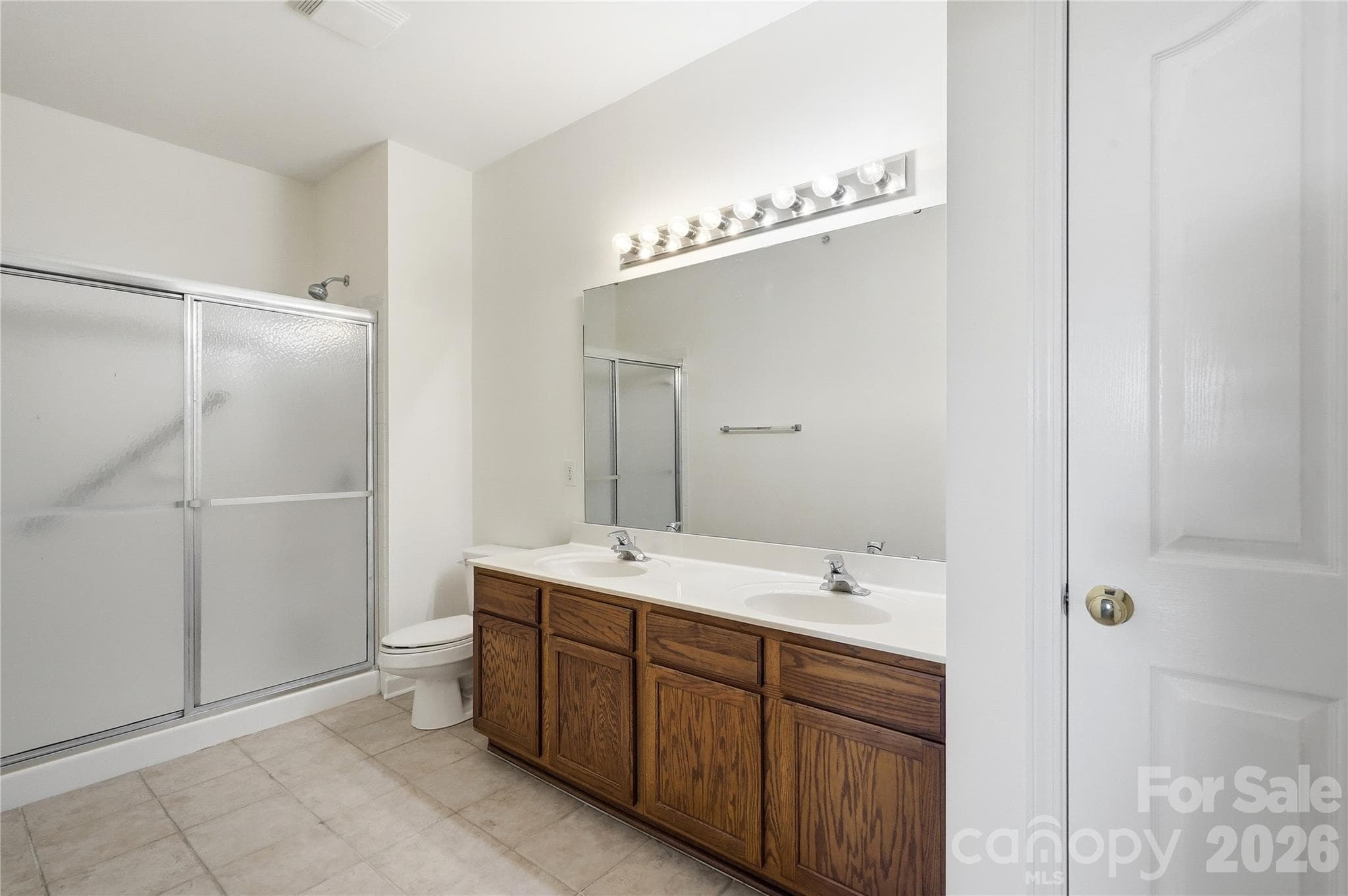 primary bath with walk-in shower and dual vanity - 16406 Redstone Mountain Lane, Charlotte