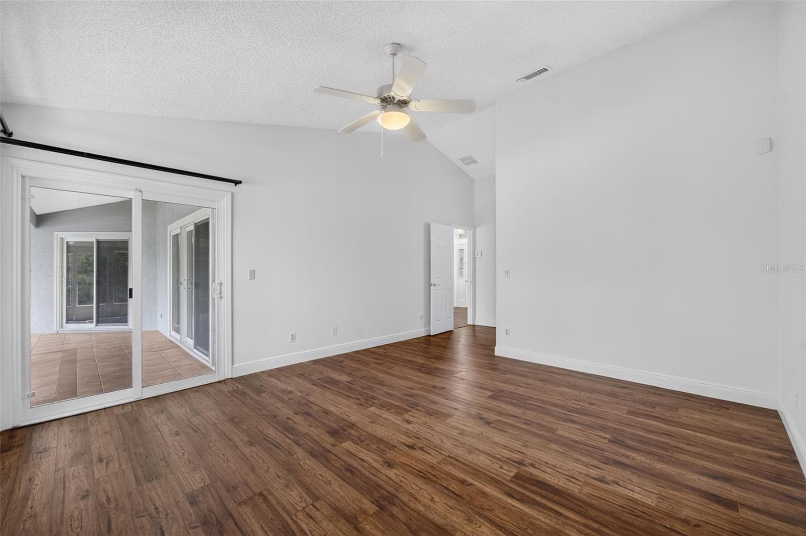 The spacious primary bedroom that opens to the large back patio and features beautiful lake views. - 2925 EAGLE LAKE DR, ORLANDO