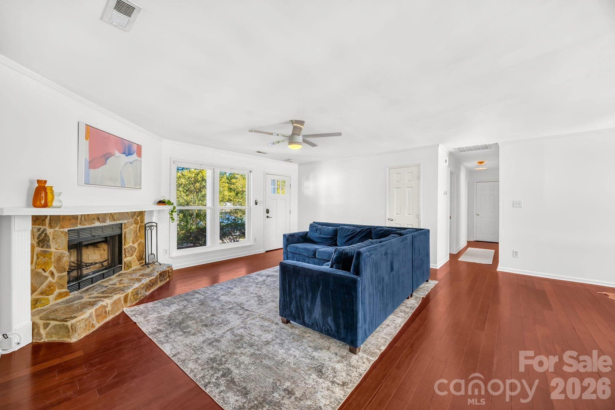Bright living room with stone fireplace and natural light in Vernedale Farms, Charlotte - 4900 Cricklewood Lane, Charlotte