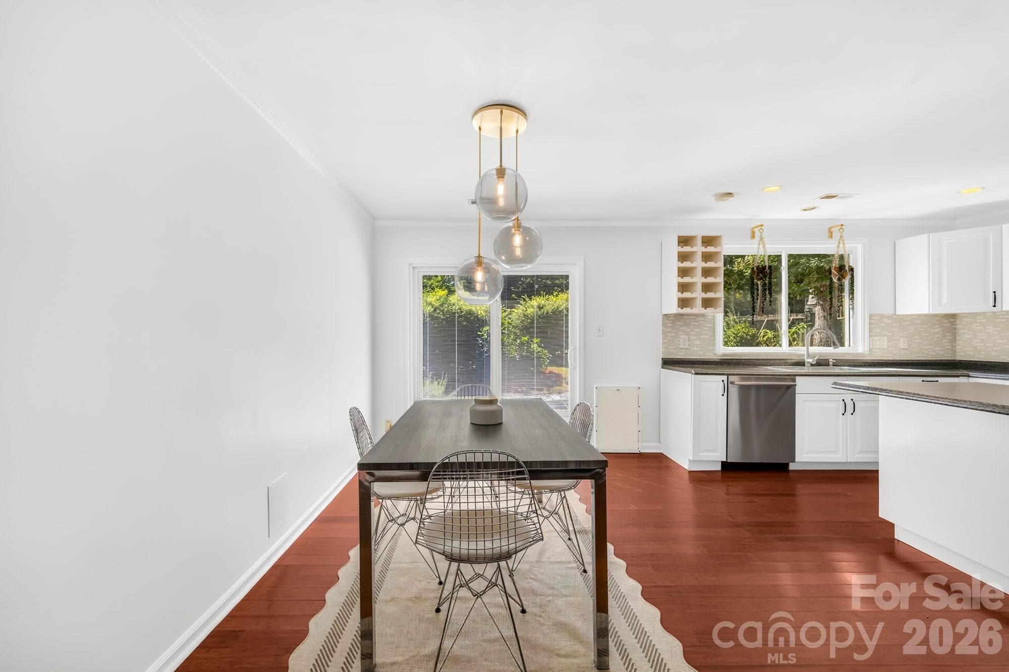 Dining area with pendant lighting and views of the backyard garden - 4900 Cricklewood Lane, Charlotte