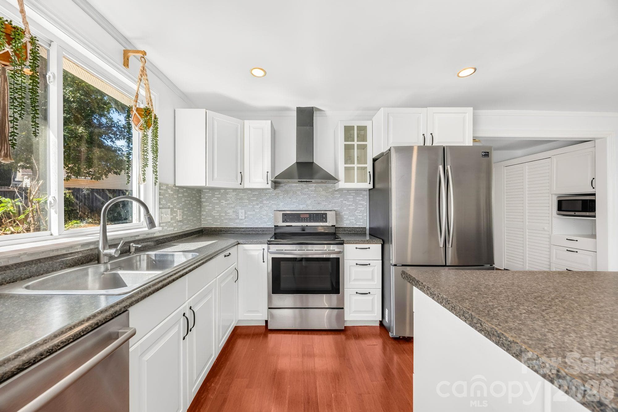 Kitchen with stainless steel range, vent hood, refrigerator and tile backsplash at 4900 Cricklewood Ln - 4900 Cricklewood Lane, Charlotte