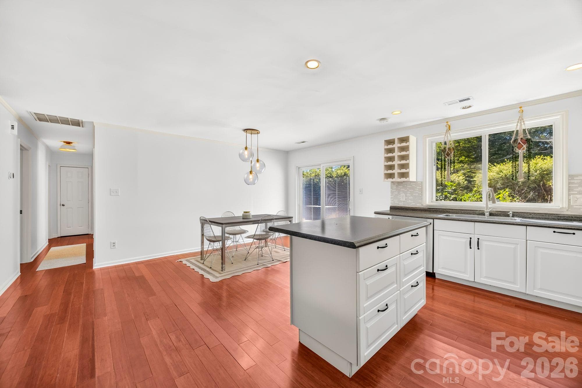 Kitchen island open to the dining area in an updated East Charlotte ranch home - 4900 Cricklewood Lane, Charlotte