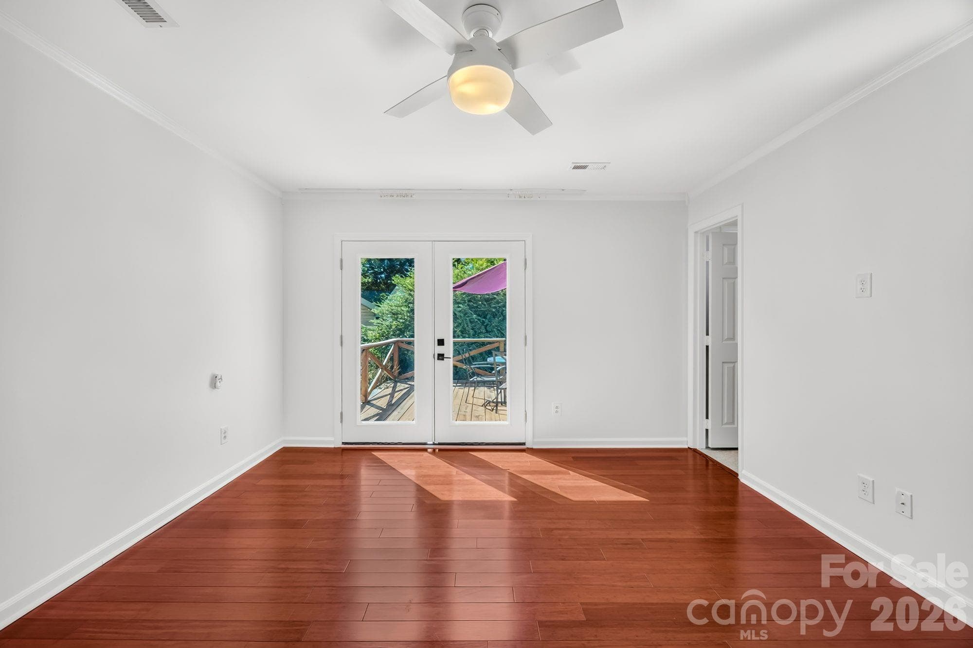 Primary bedroom with French doors to the back deck in a one-story Charlotte home - 4900 Cricklewood Lane, Charlotte