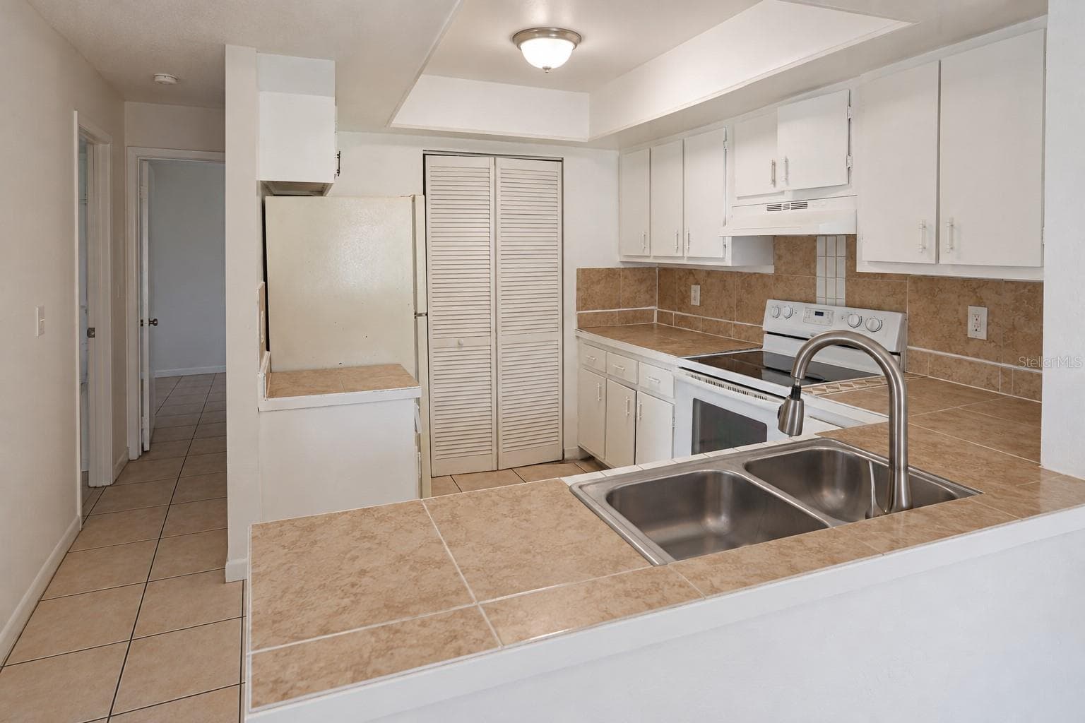 Kitchen with pantry and opening from dining area. Bedrooms at left. - 2527 CITRUS CLUB LN #3904, ORLANDO