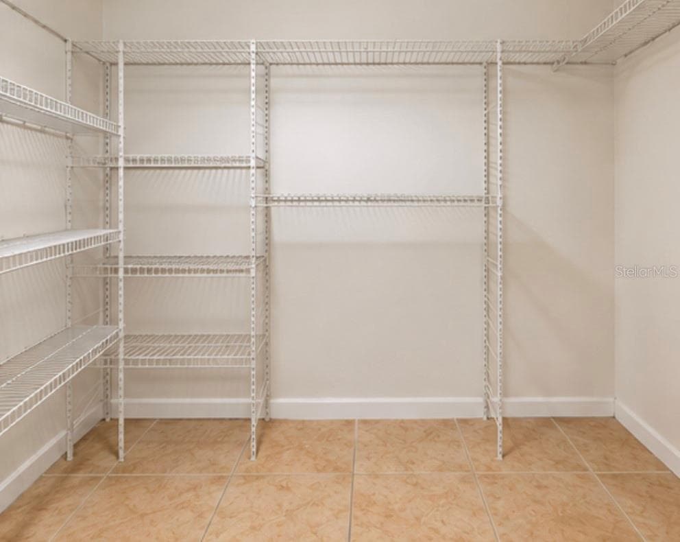 Spacious walk-in closet with added shelving. - 2527 CITRUS CLUB LN #3904, ORLANDO