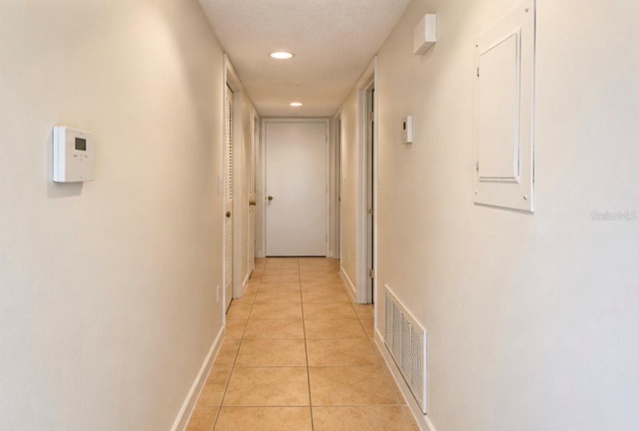 Hallway to bedrooms; laundry closet at far end right. - 2527 CITRUS CLUB LN #3904, ORLANDO