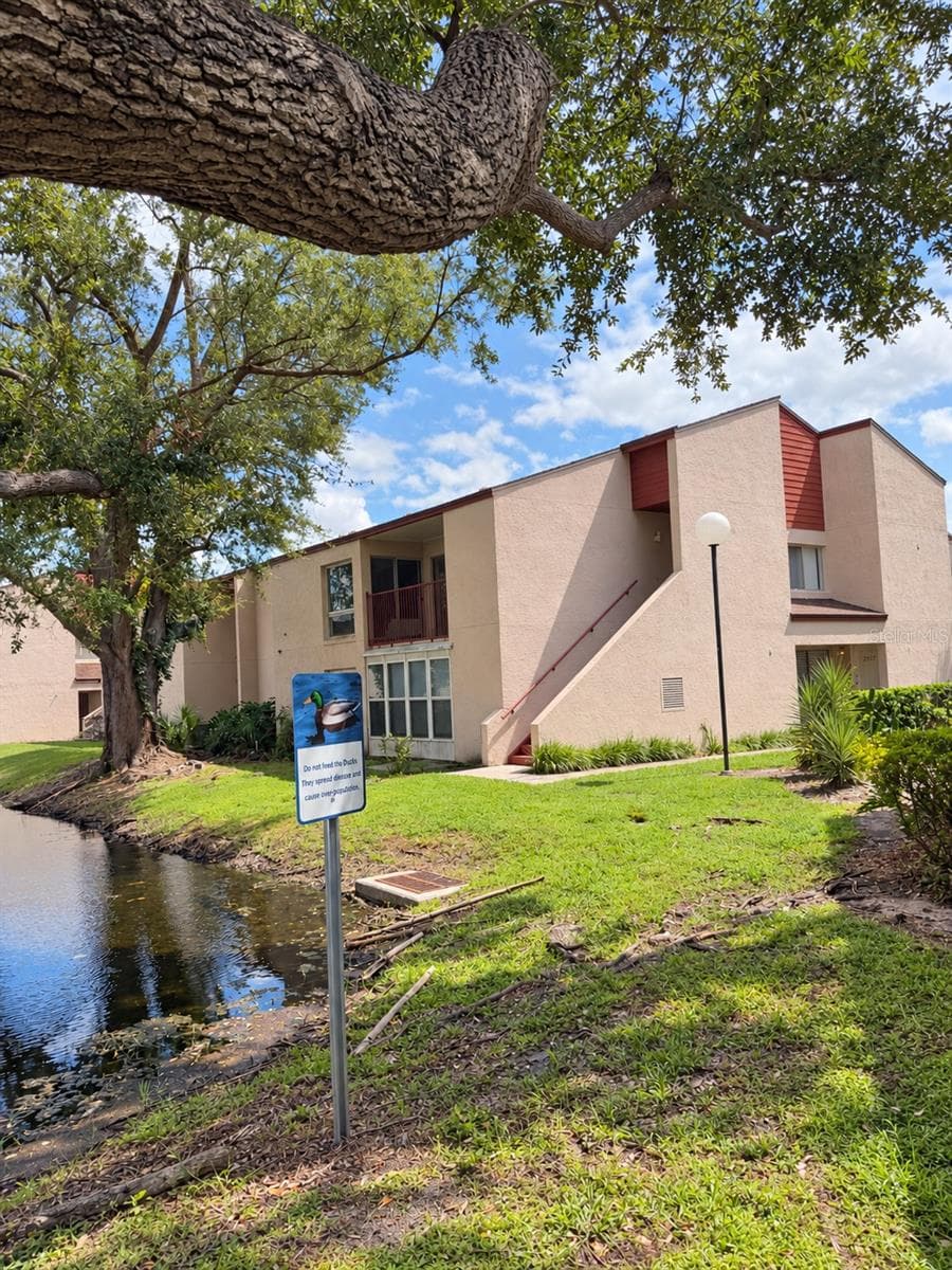 Exterior view framed by oak trees. - 2527 CITRUS CLUB LN #3904, ORLANDO