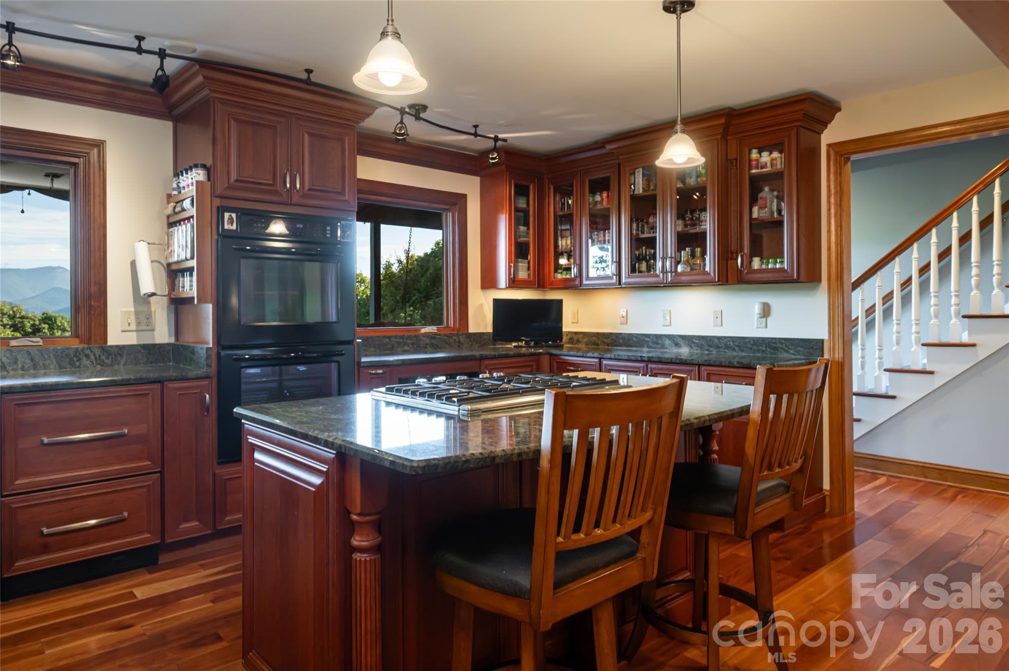 The kitchen is highlighted by a center island, granite tops, and cherry cabinetry. - 126 Wildflower Cove Drive, Swannanoa