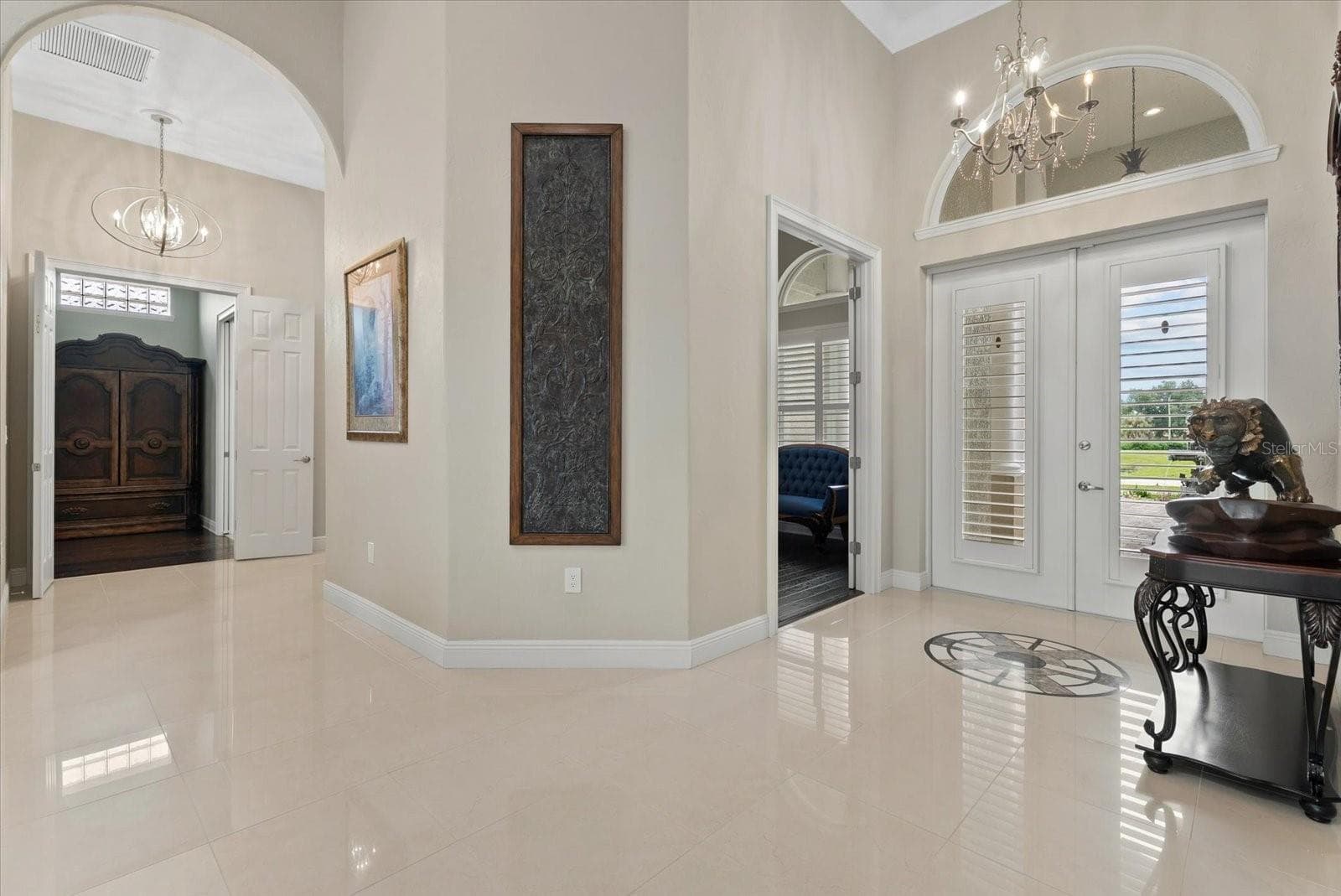 Looking back towards the front entry, door to the study and french doors entry to the primary suite - 520 RYE RD NE, BRADENTON