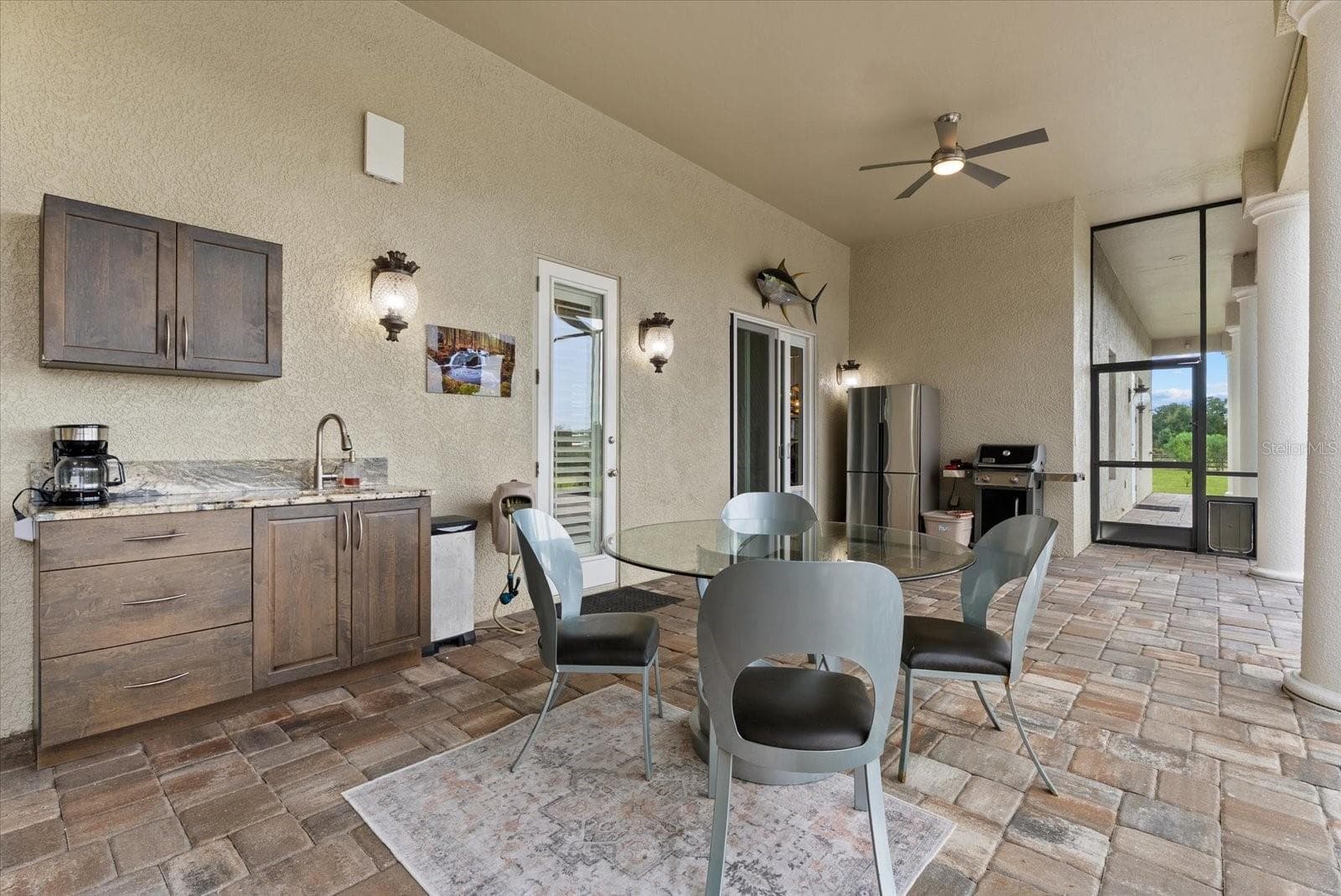 The second outdoor lounge area is off the family room/kitchen area, and offers access to the half bath off the media room - 520 RYE RD NE, BRADENTON
