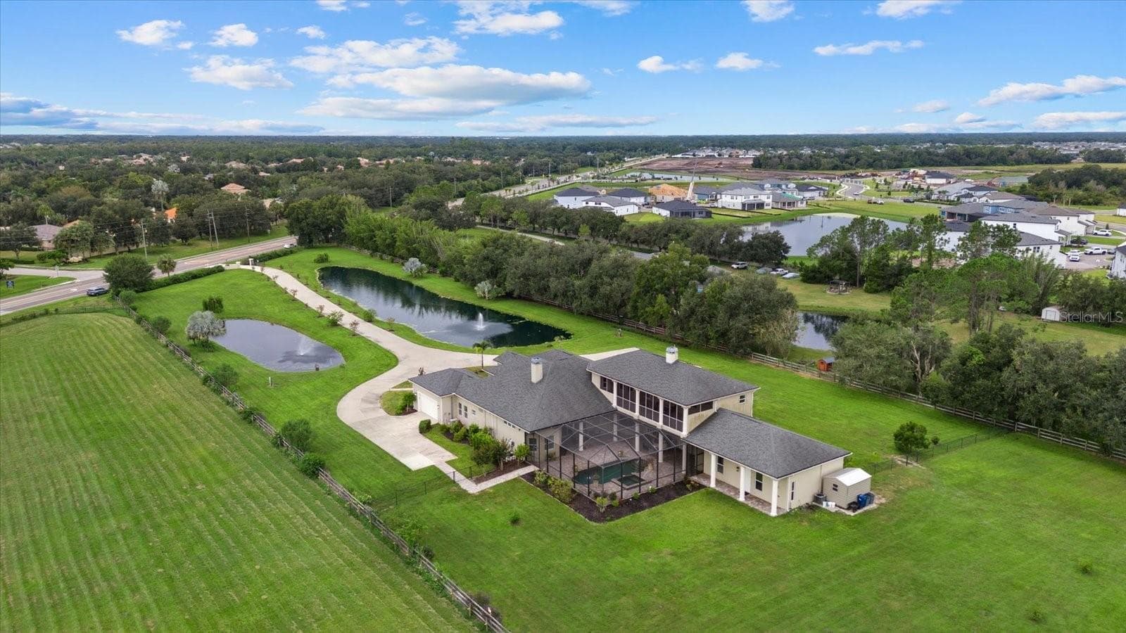 This drone shot shows the property entrance and long driveway - 520 RYE RD NE, BRADENTON