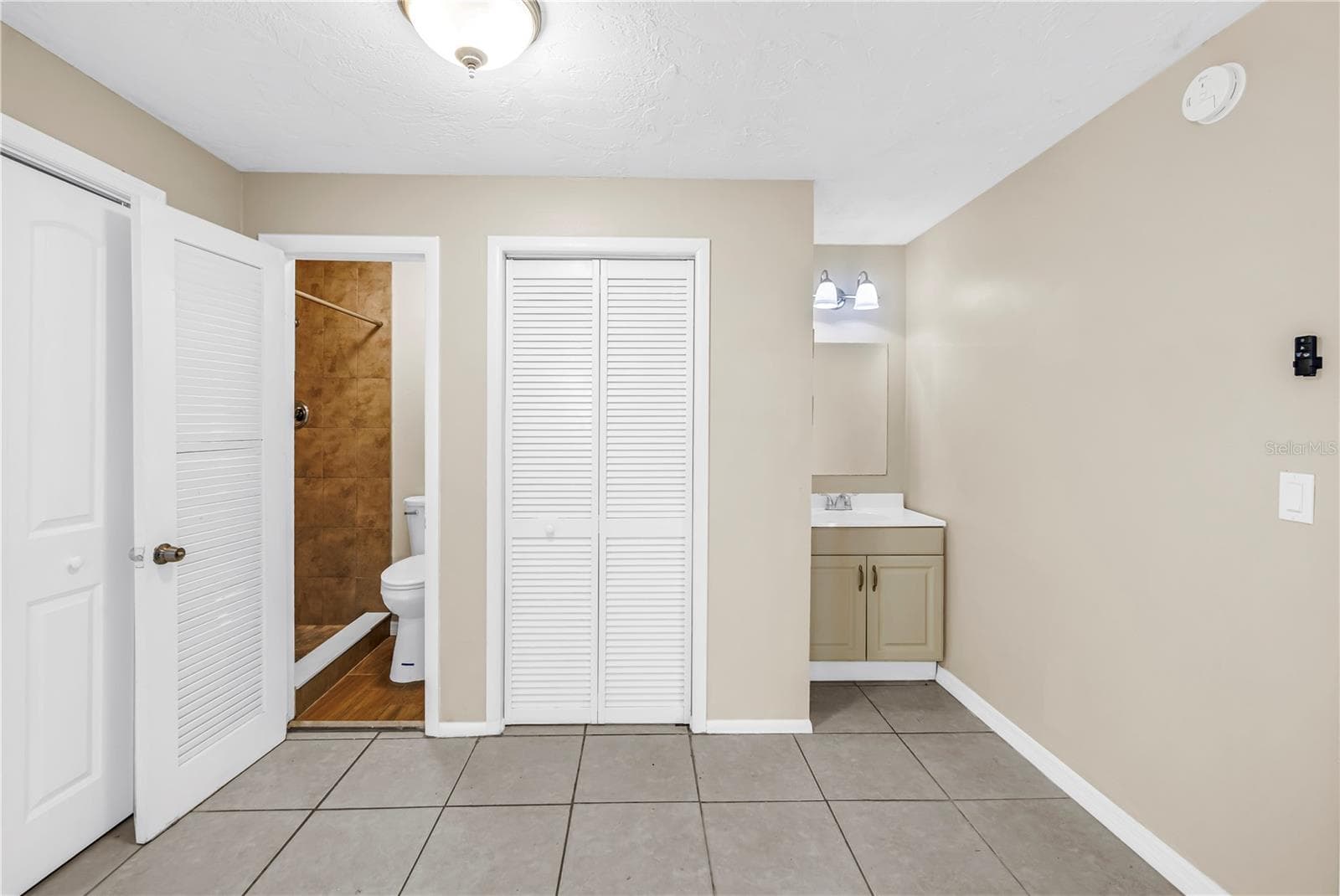 primary bedroom including bathroom and sink - 1516 DERRICK ST, HOLIDAY